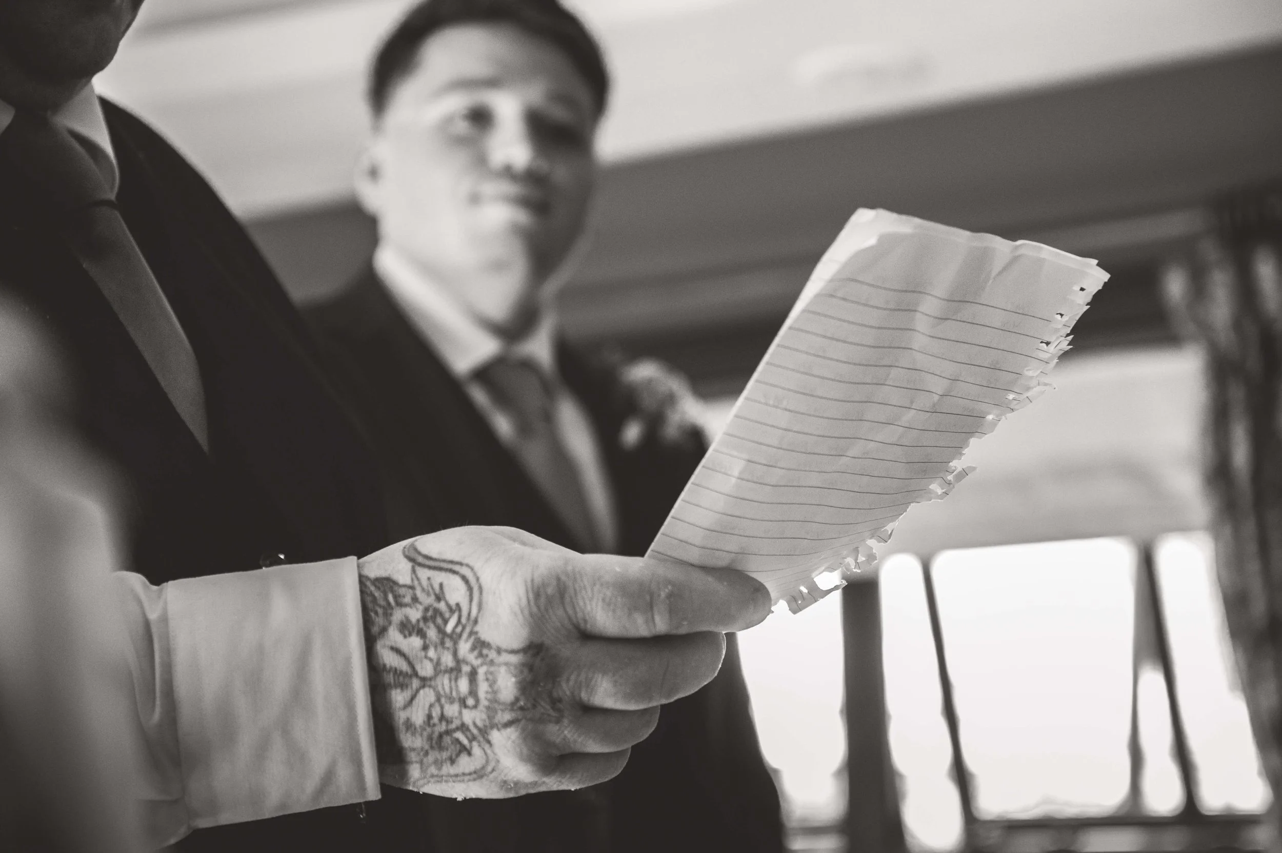 father of the bride reads his speech as groom looks on 