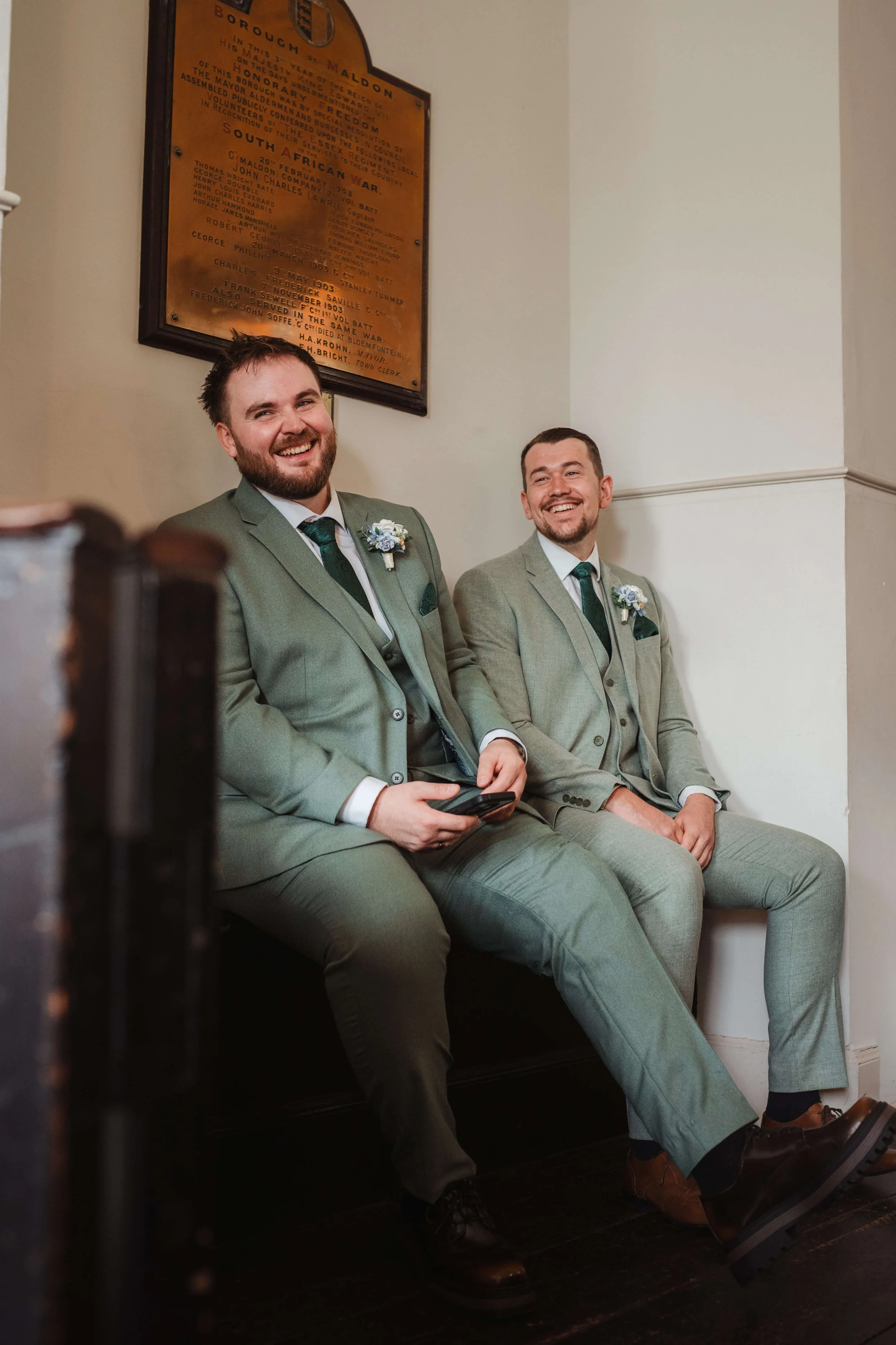 groomsman sharing a joke in the pews