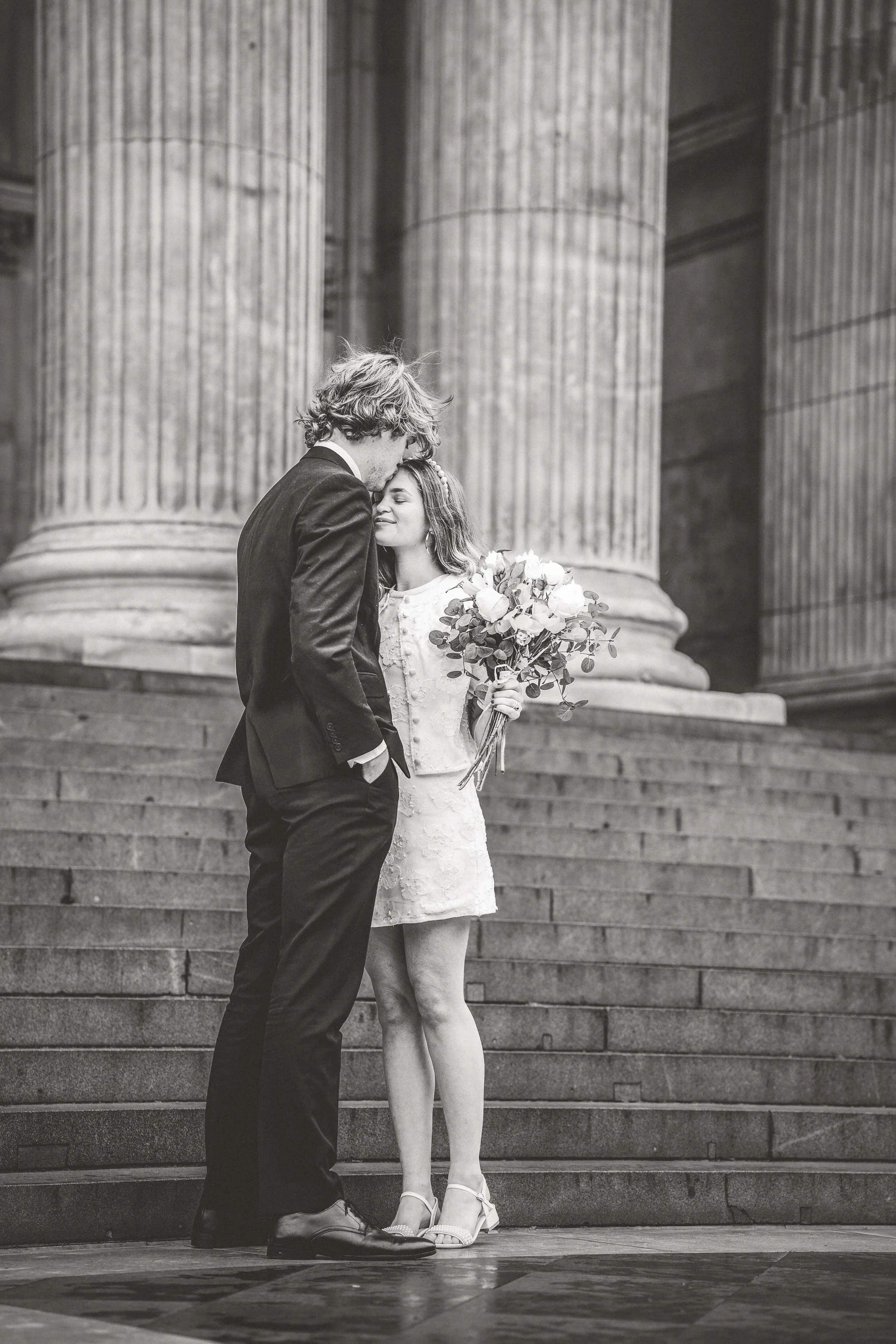 Groom kisses brides head on steps of St Pauls Cathedral 