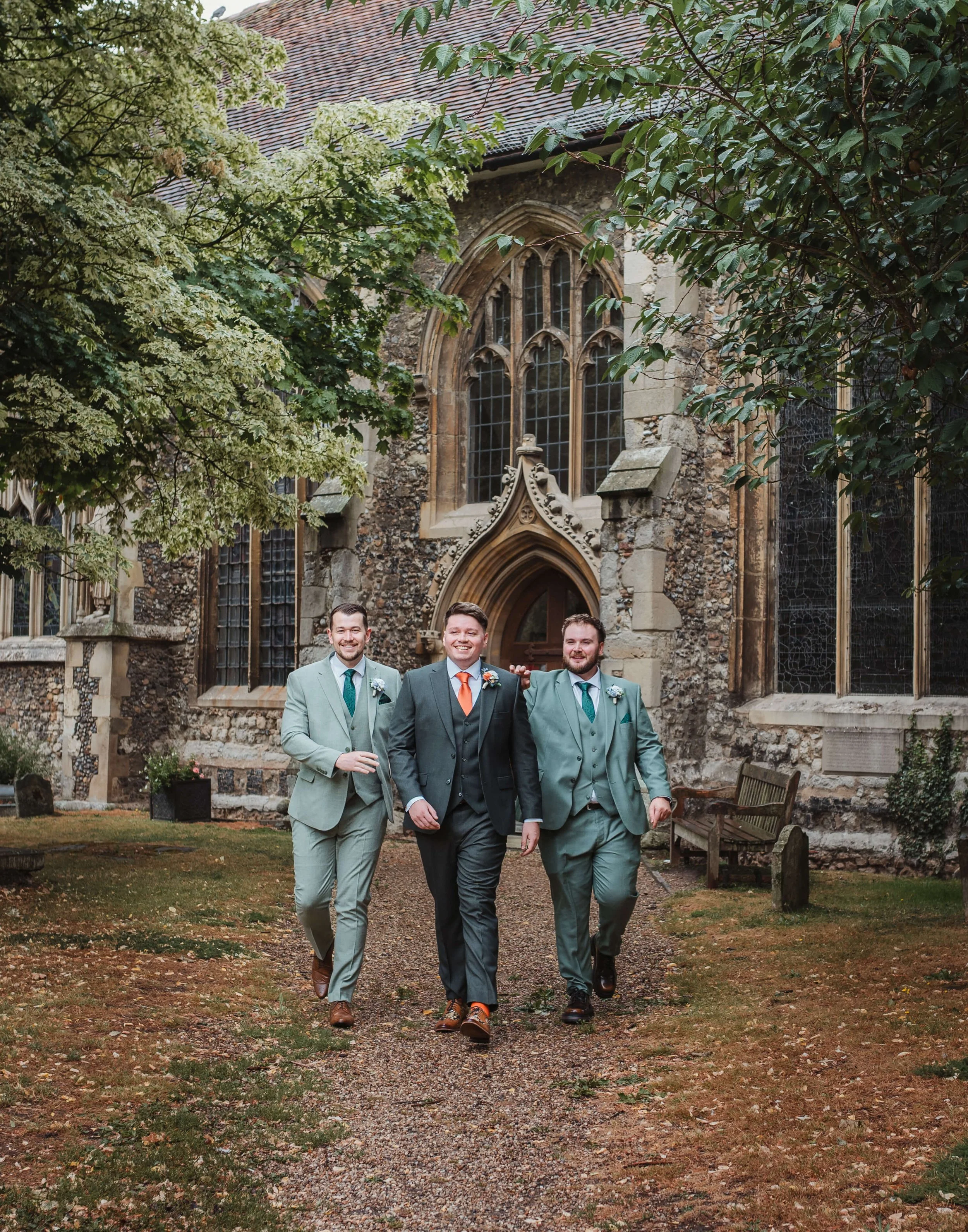 groom and his groomsmen walking and joking outside church