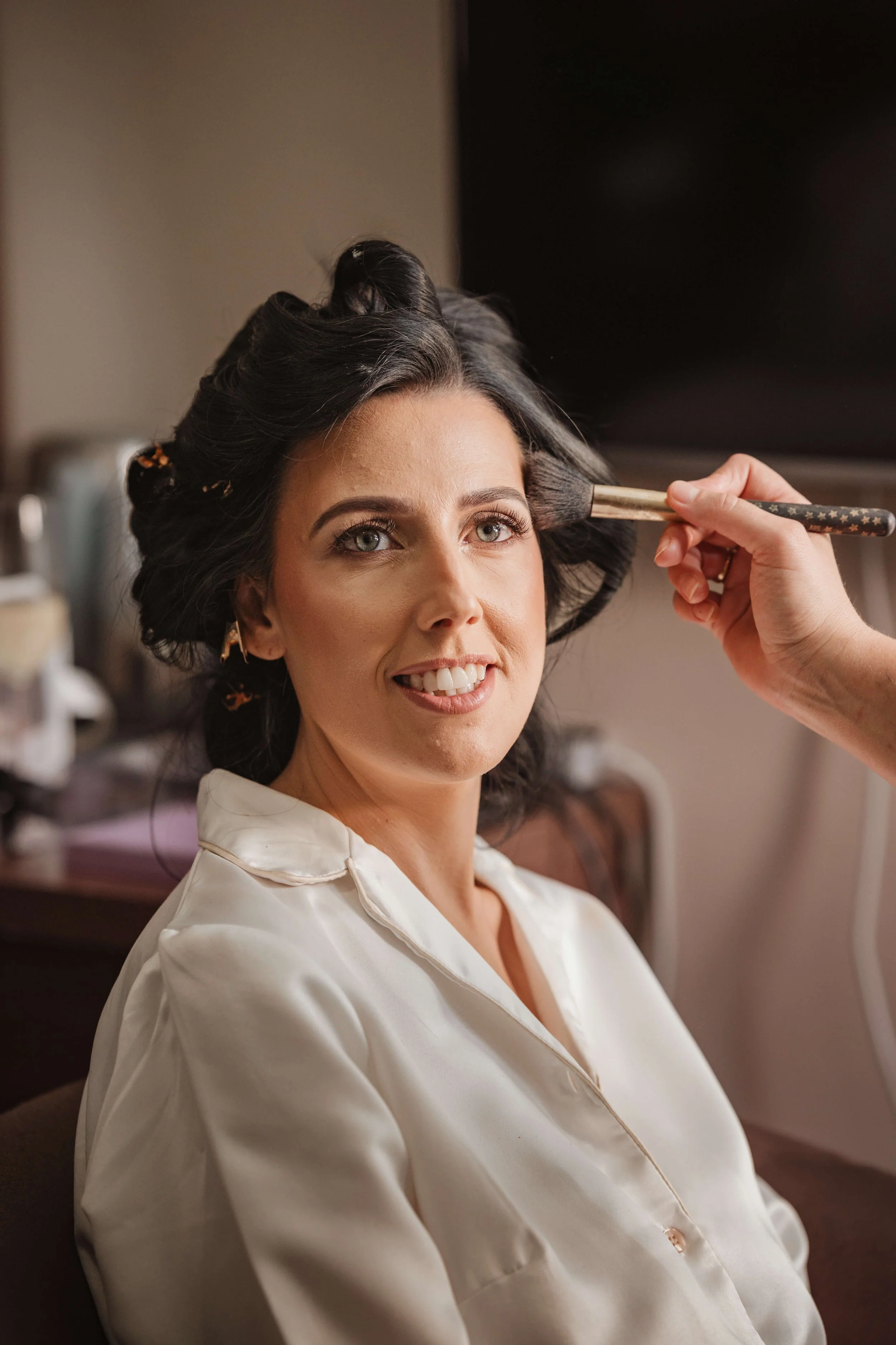 bride getting ready with professional make up artist before ceremony