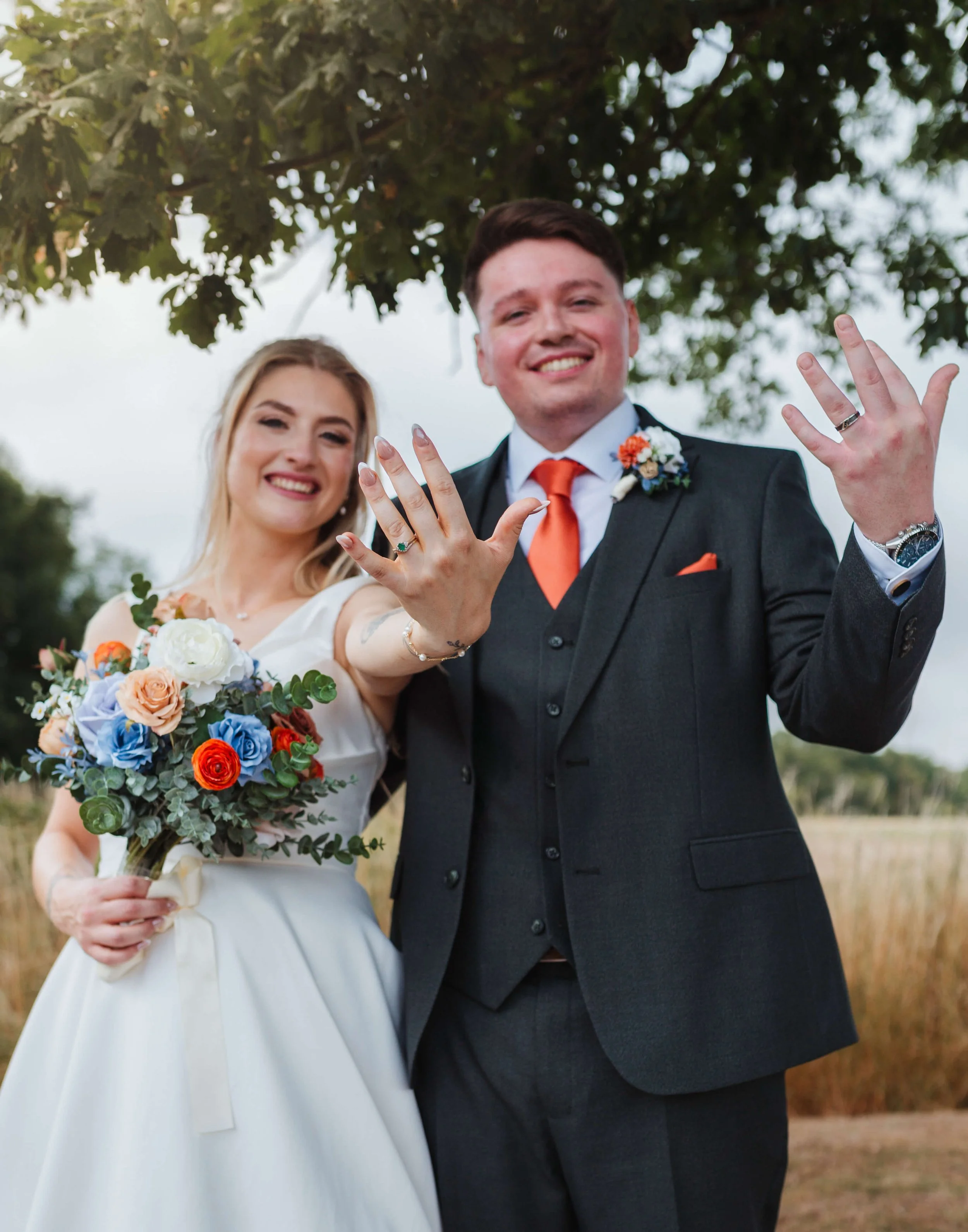 bride and groom showing of their wedding rings 