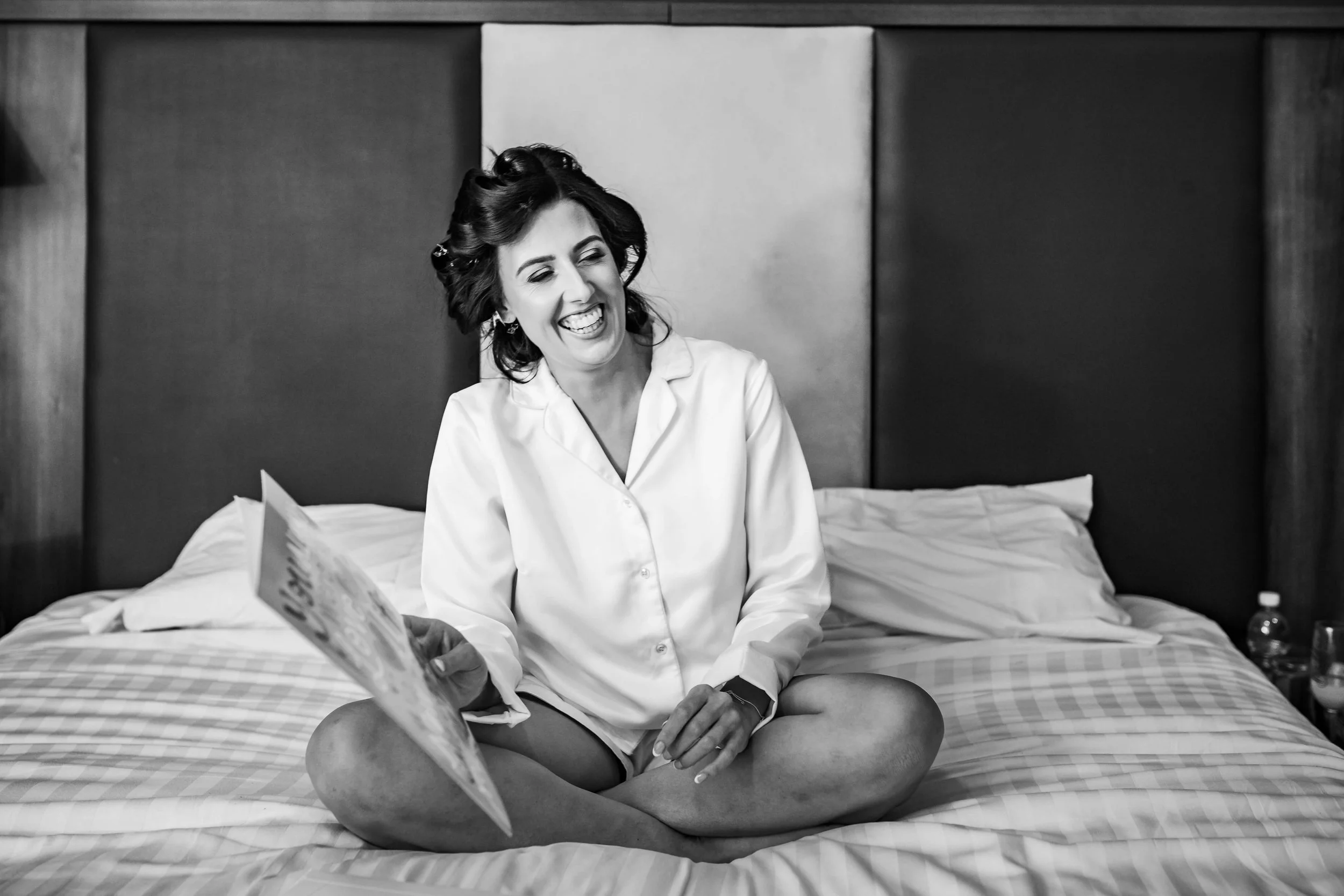 bride opening card from groom, laughing and happy