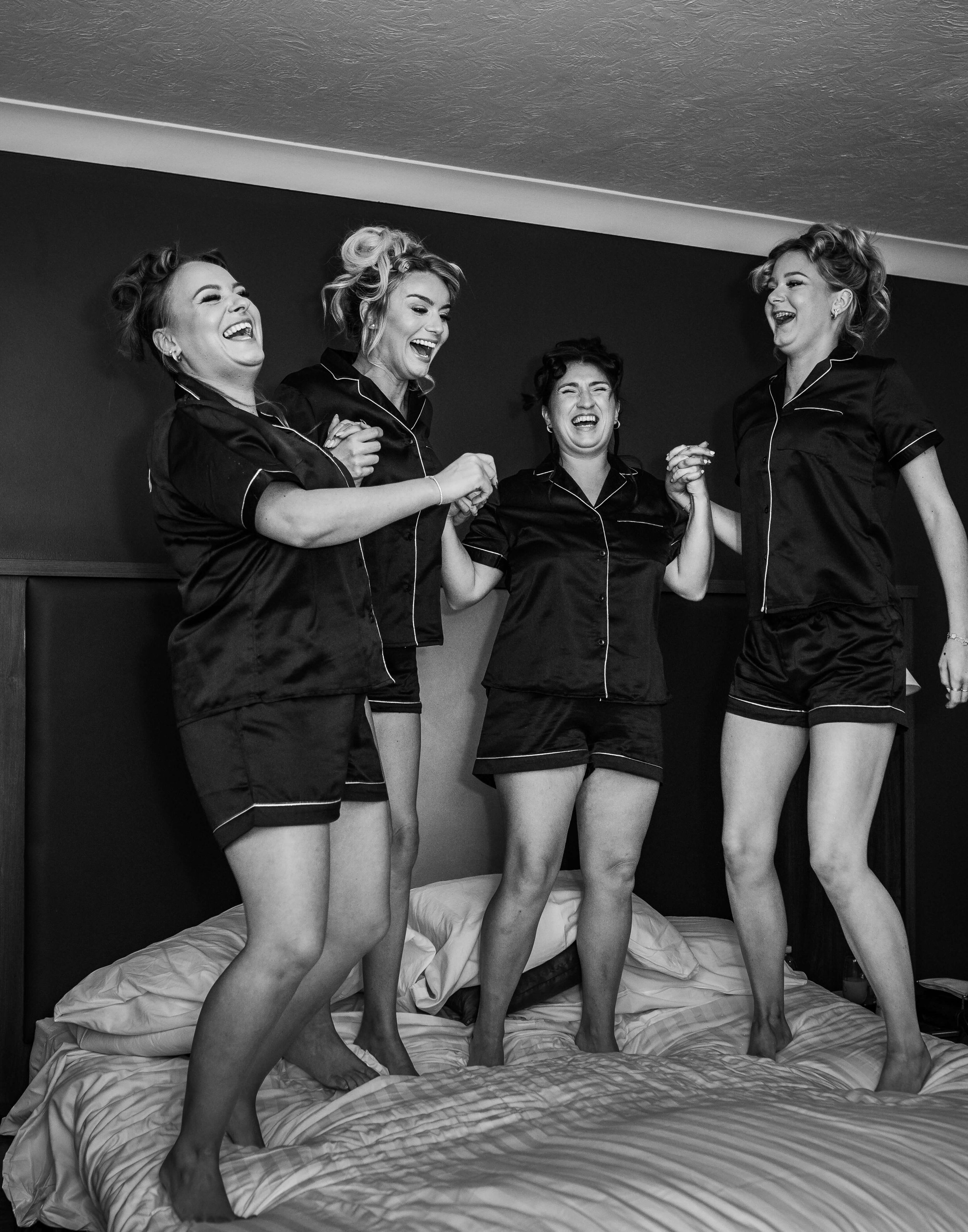 bridesmaids jumping on bed