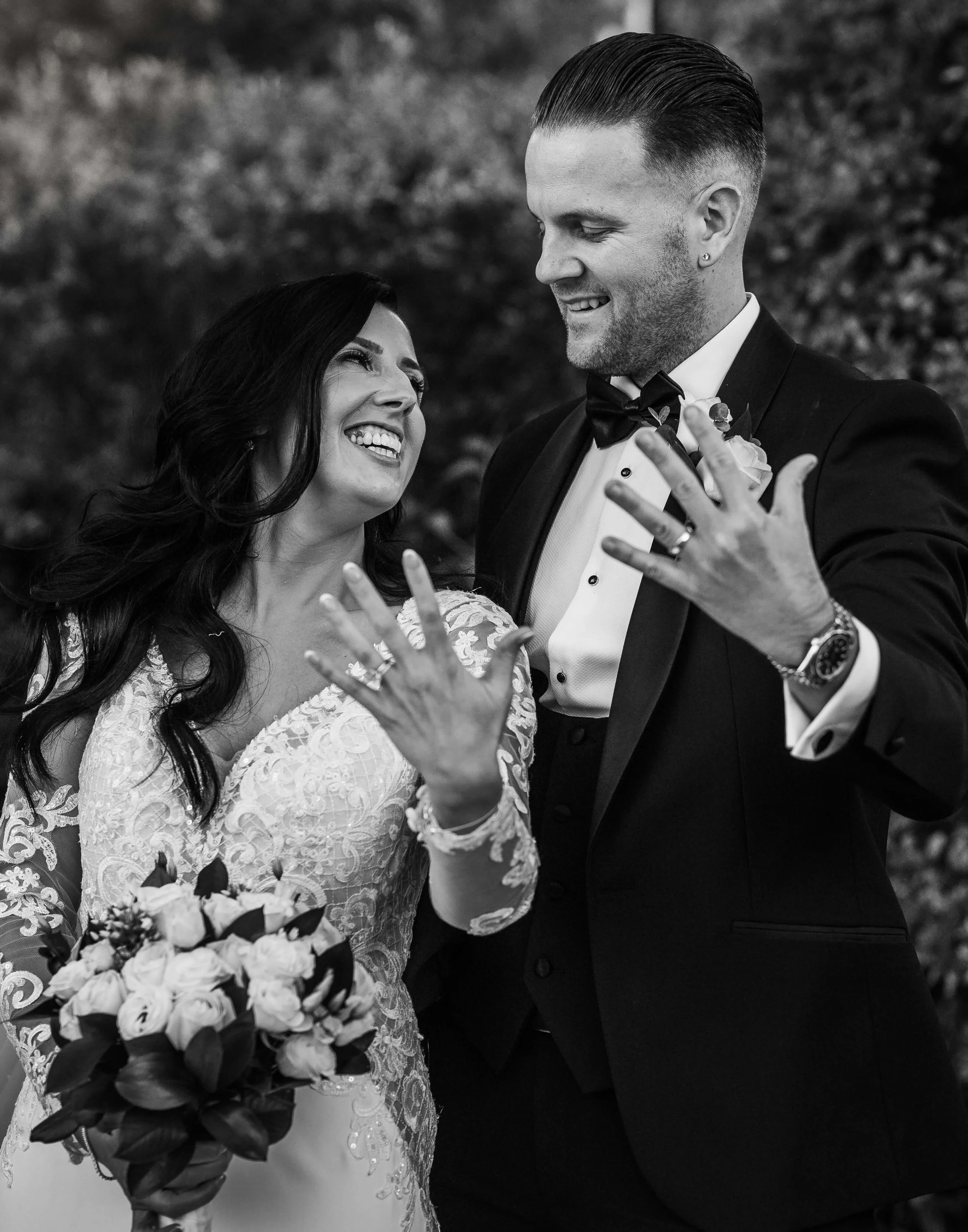 bride and groom showing off their rings 
