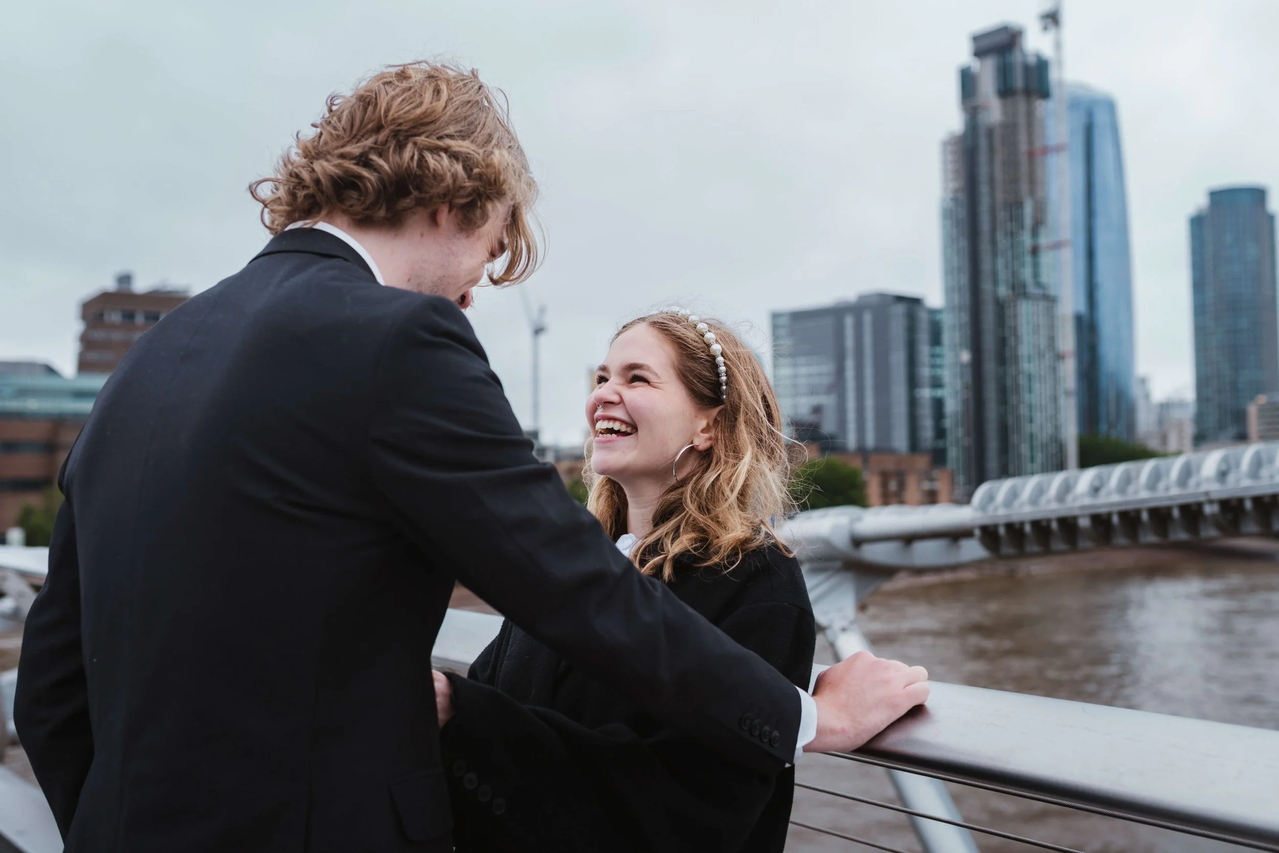 bride and groom laughing on millennium bridge 