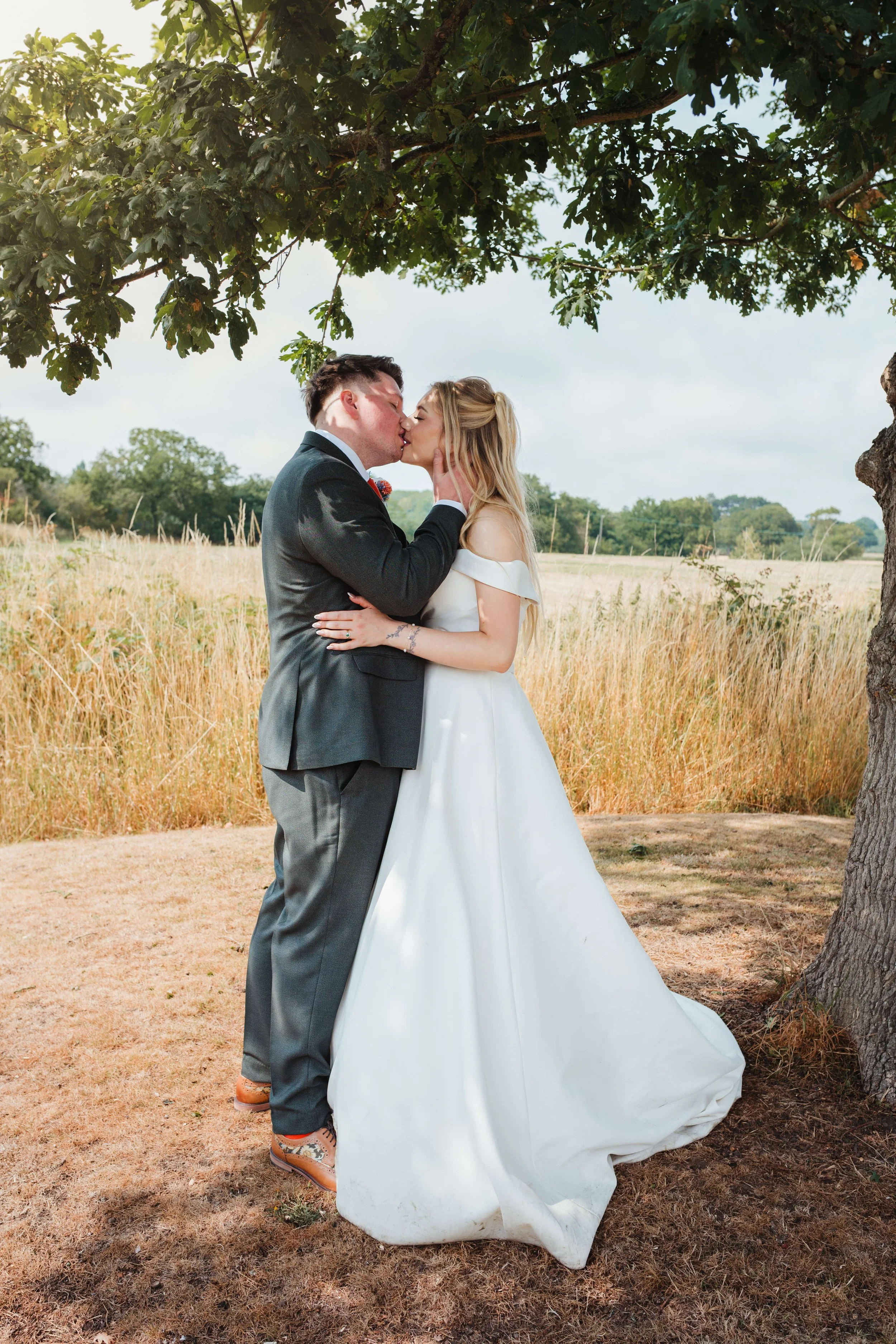 couple embrace under a tree 