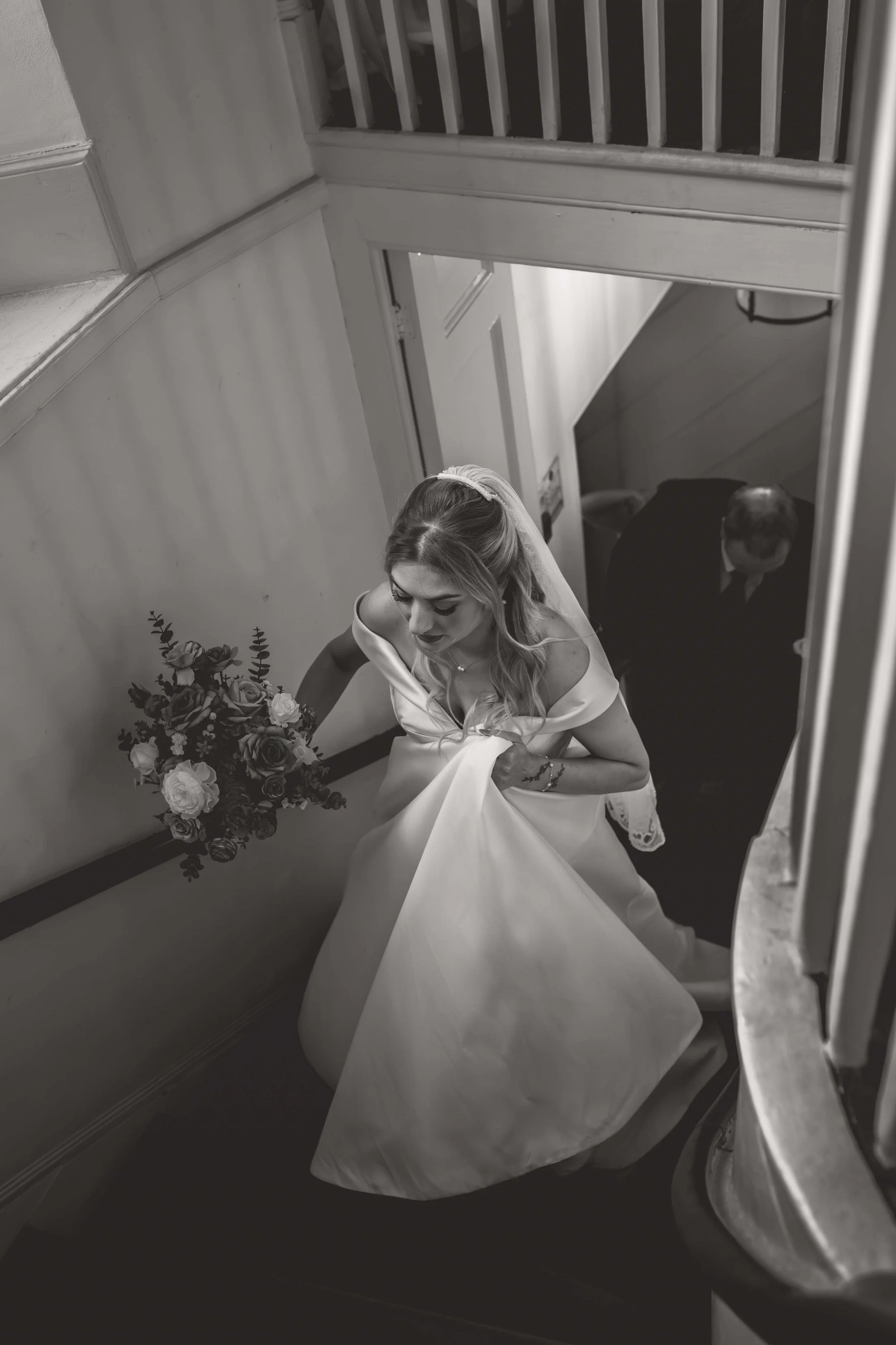 bride climbing stairs to her ceremony in black and white