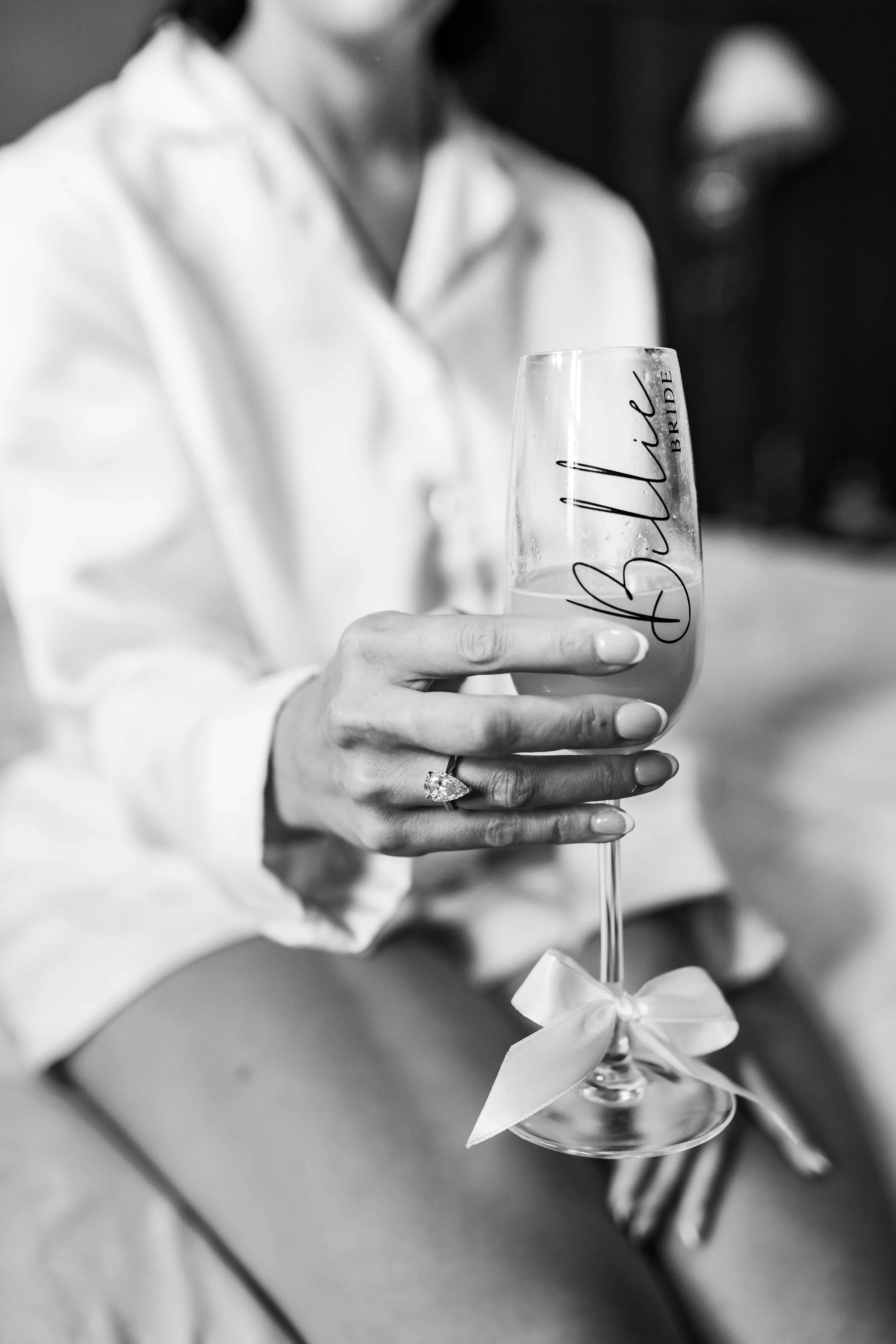 personalised bride glass with champagne being held by bride
