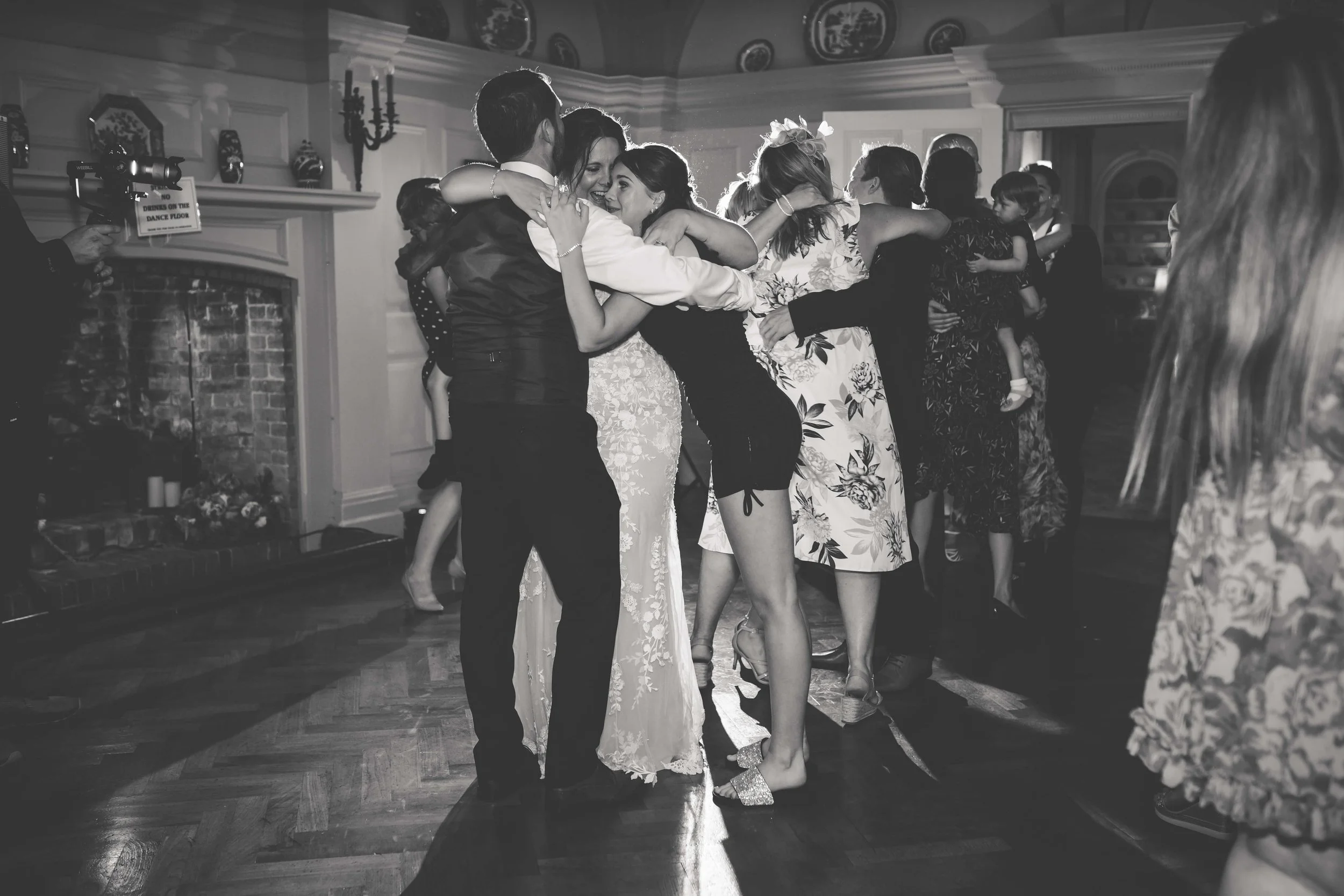 Group of people dancing and hugging at a celebration event in a decorated indoor venue