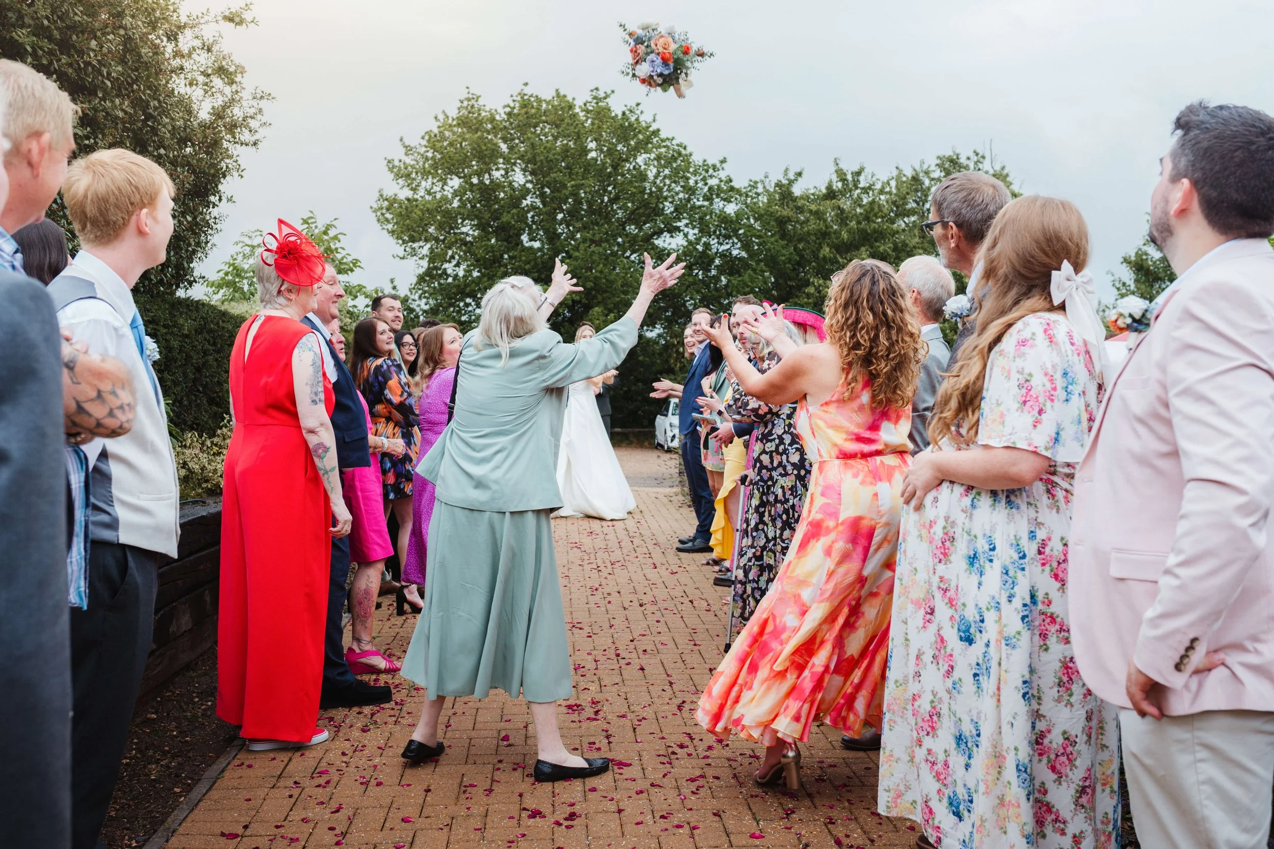 nan catches bouquet as guests watch on in amusement 