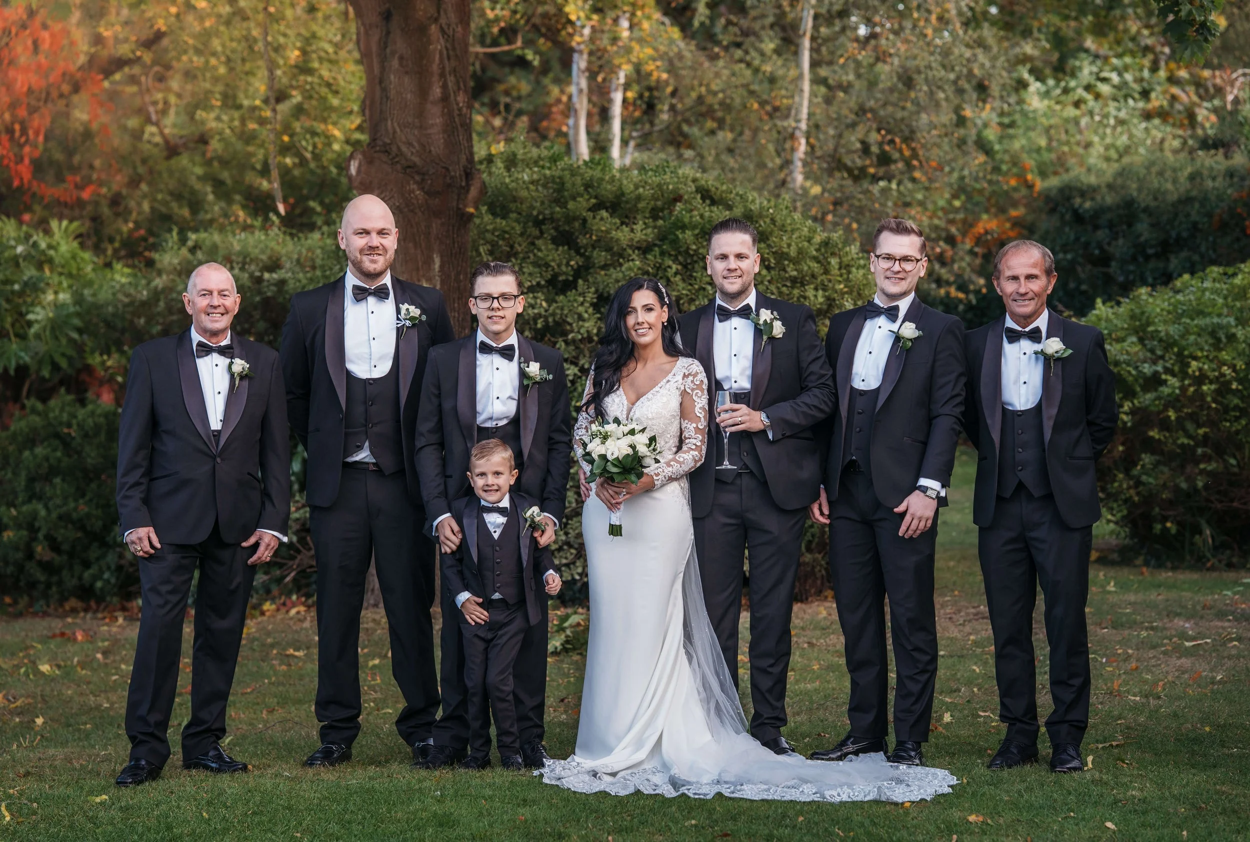 bride and groom with groomsmen group shot in garden at the Rochford hotel essex