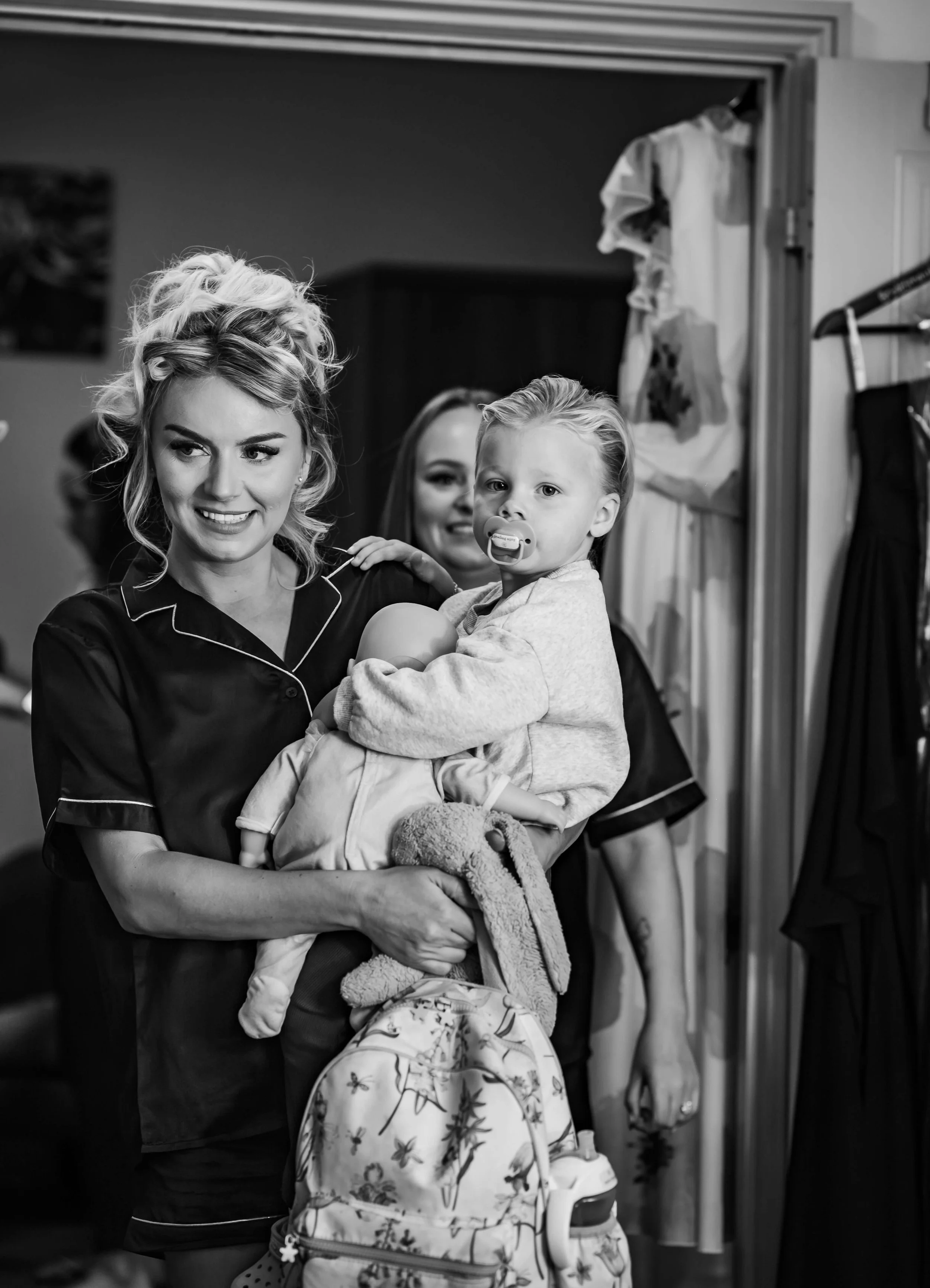 bridesmaid holding young flower girl before getting ready