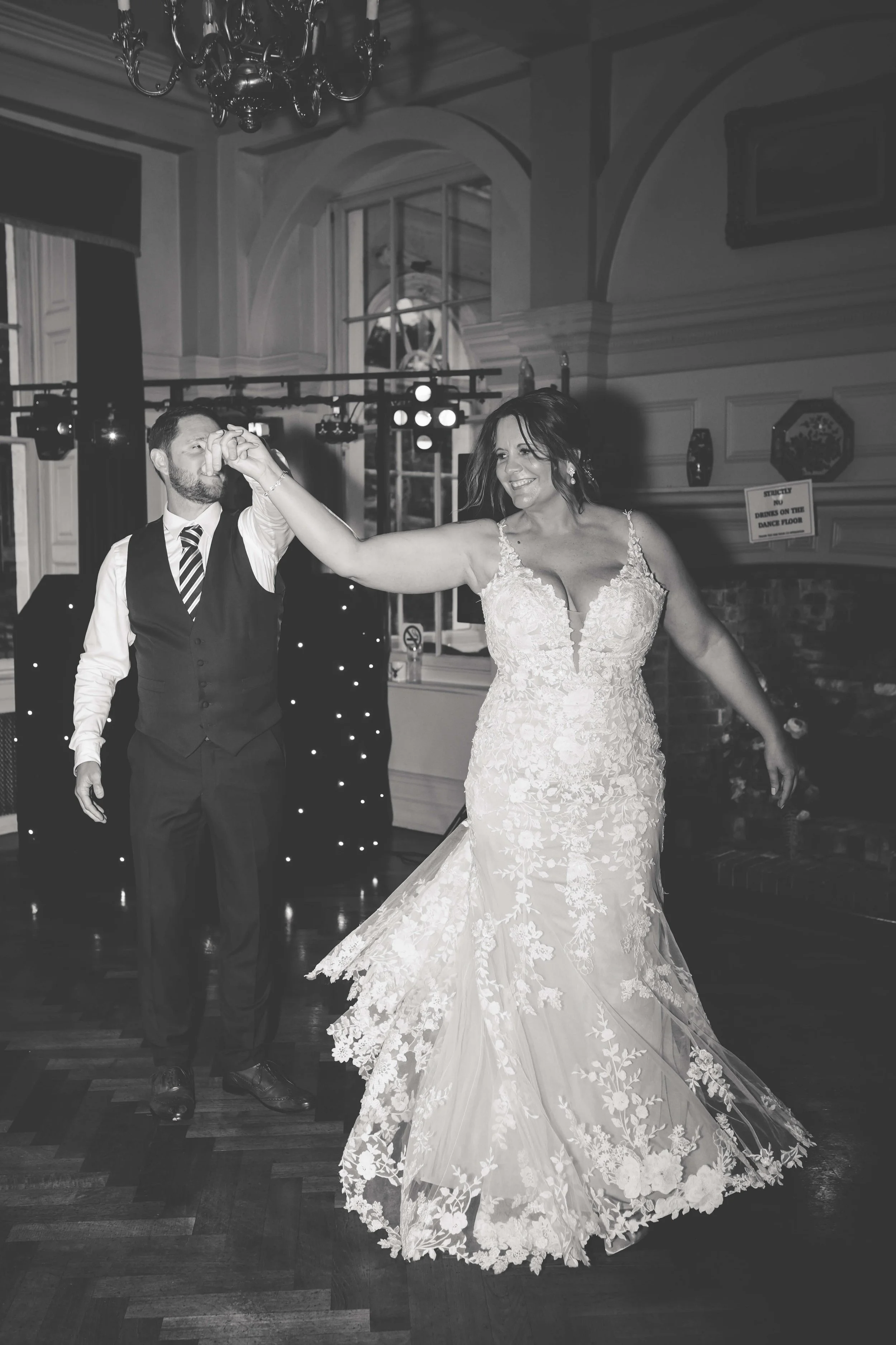 A bride and groom dancing at their wedding reception indoors.