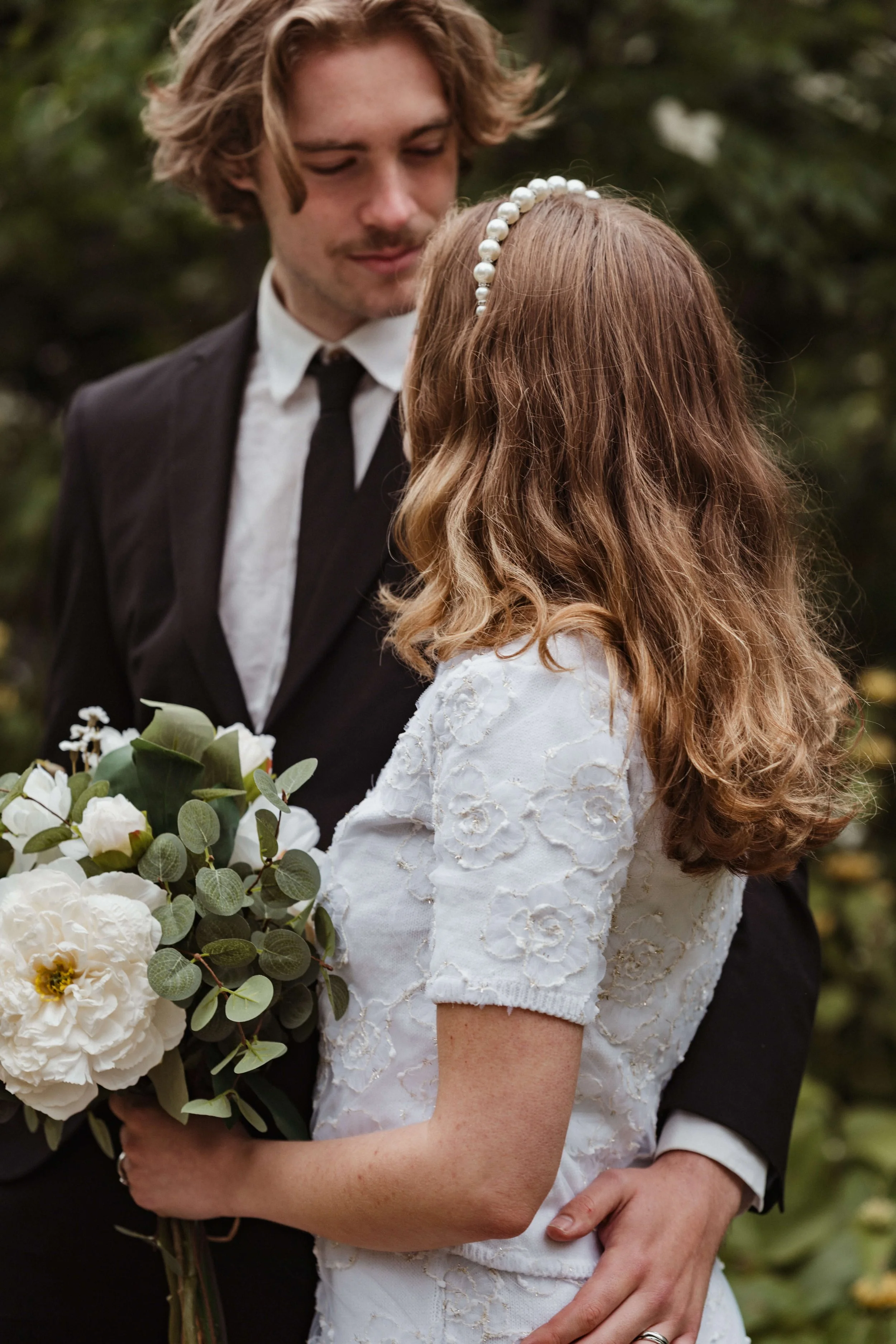 Groom looks at bride in gardens in London