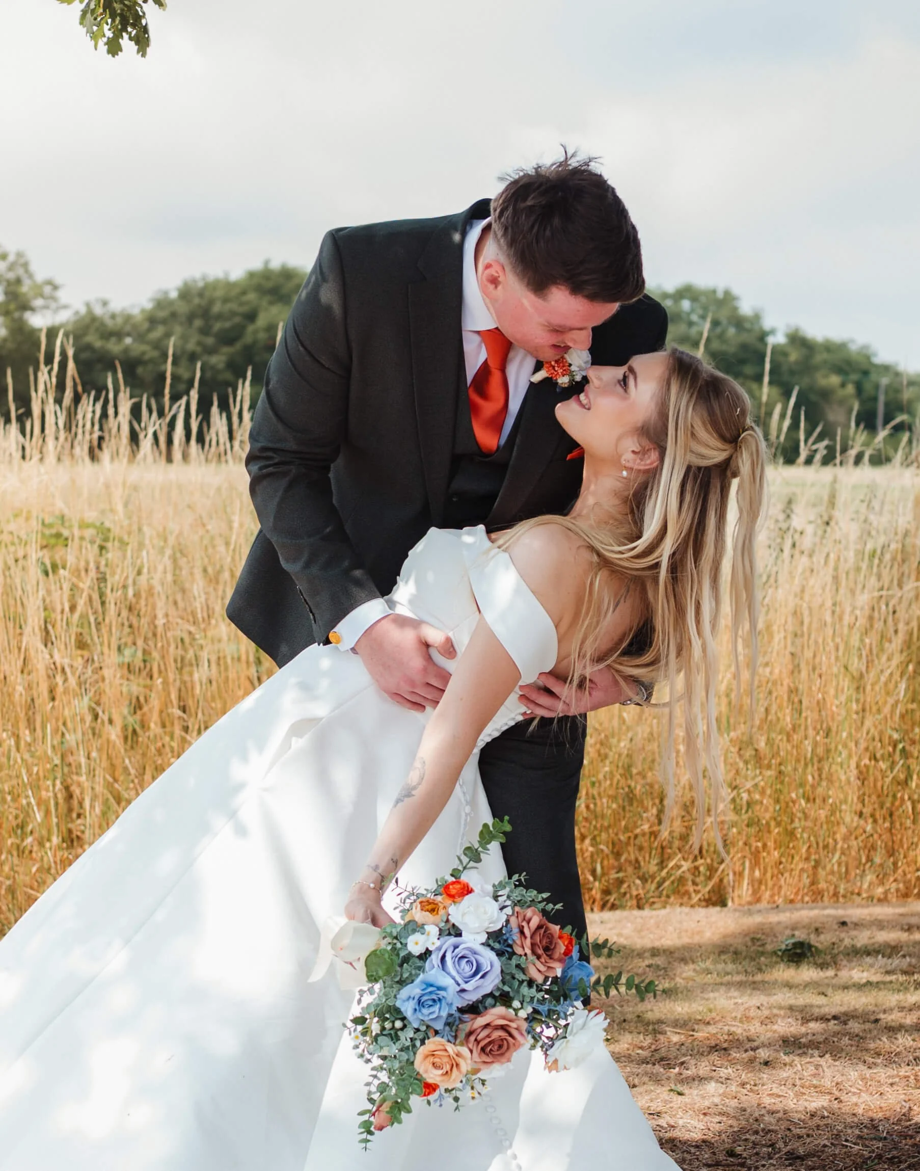 groom stares into brides eyes as he dips her for a kiss