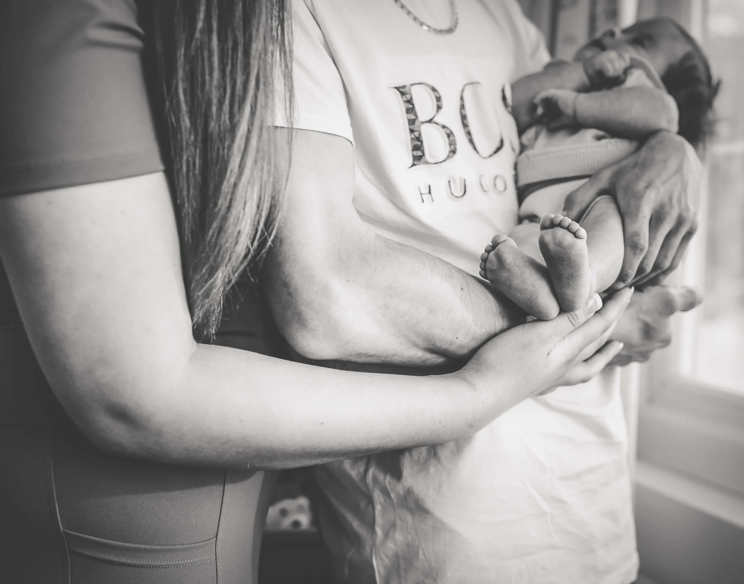 mum and dad holding baby in black and white 