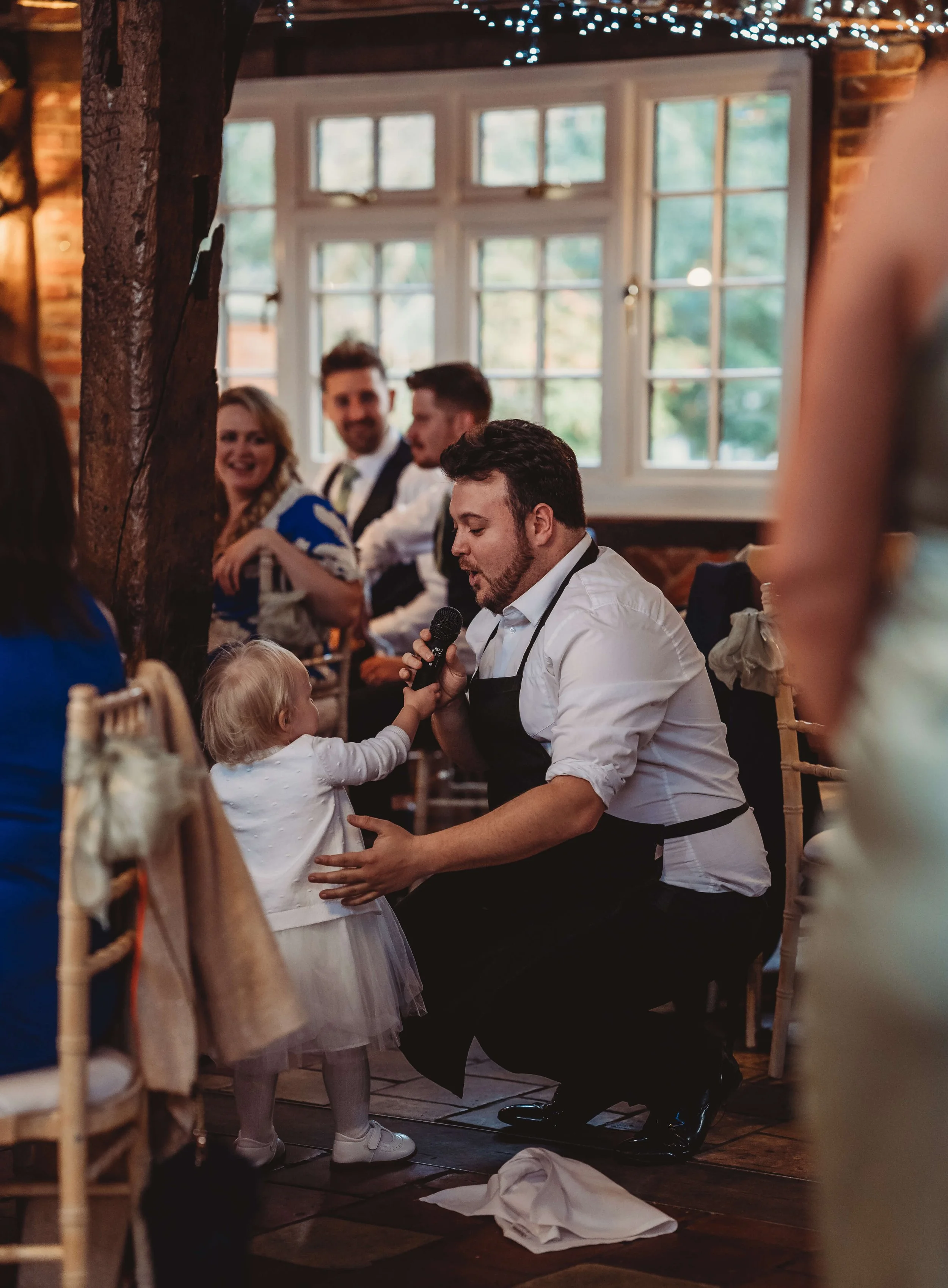singing waiter sings to flower girl at wedding reception