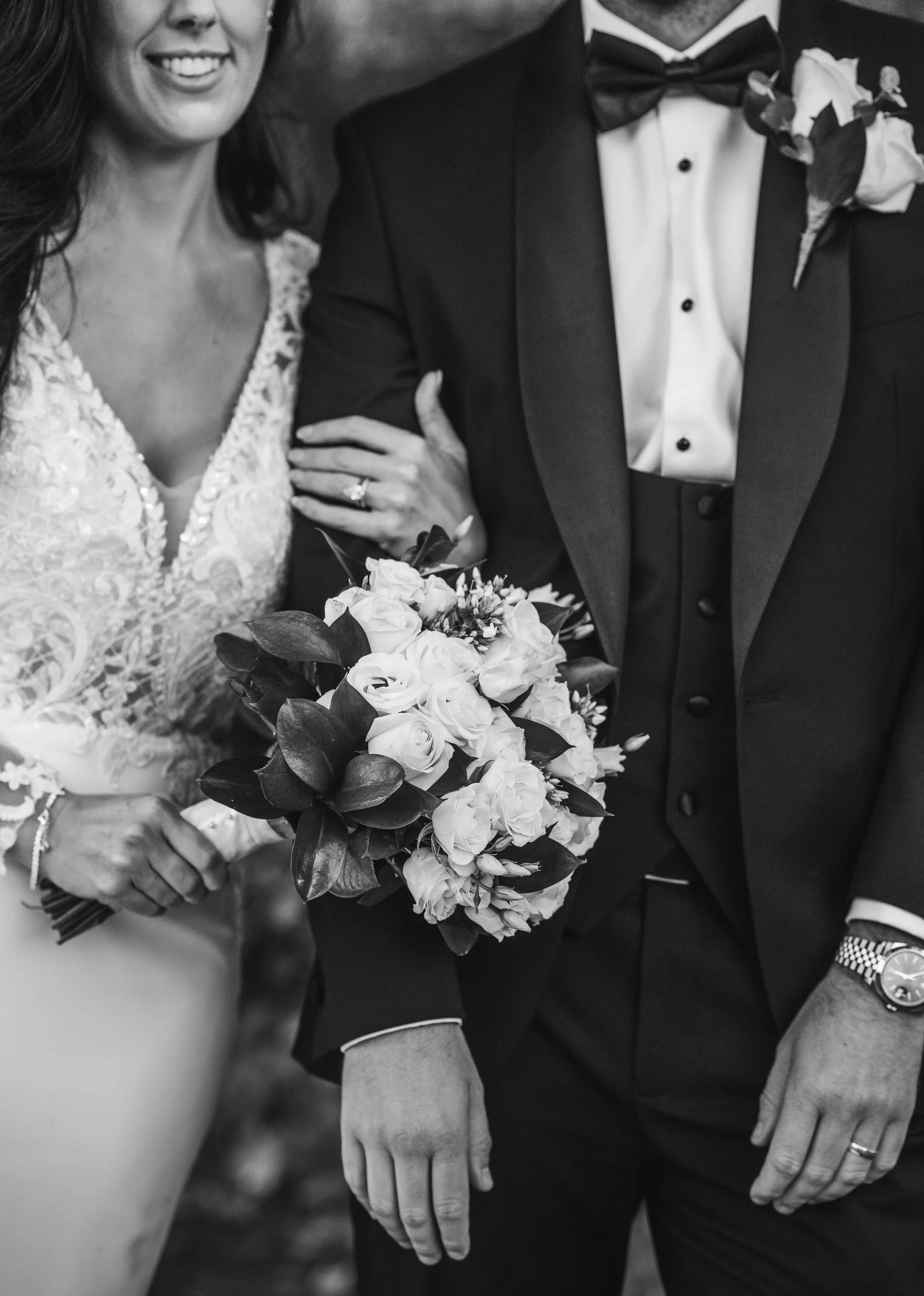 close up editorial photo in black and white of brides bouquet and grooms watch and their wedding rings