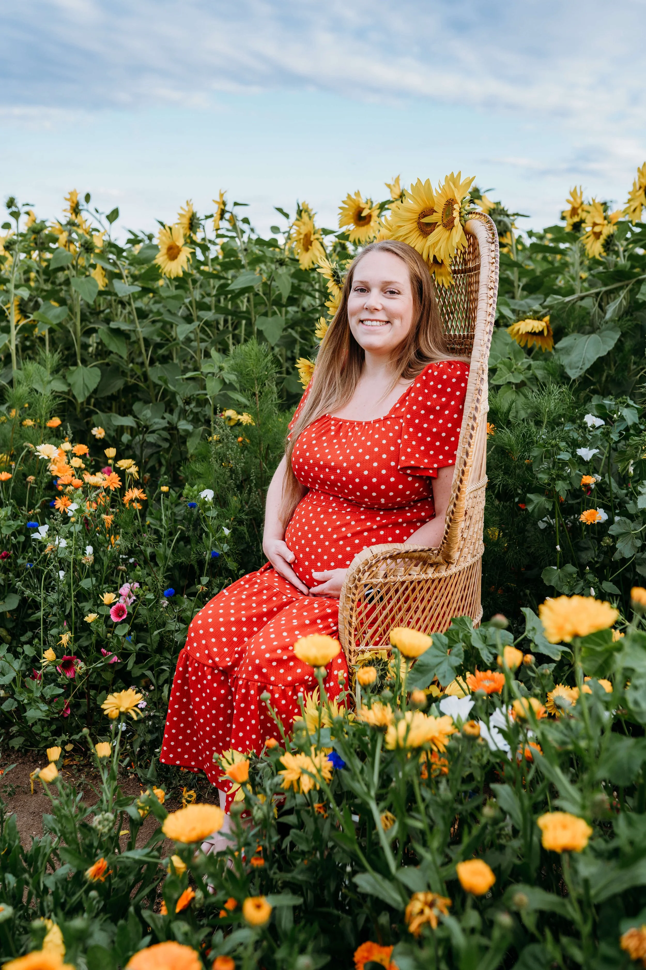 pregnant mum in peacock chair in sunflower field 