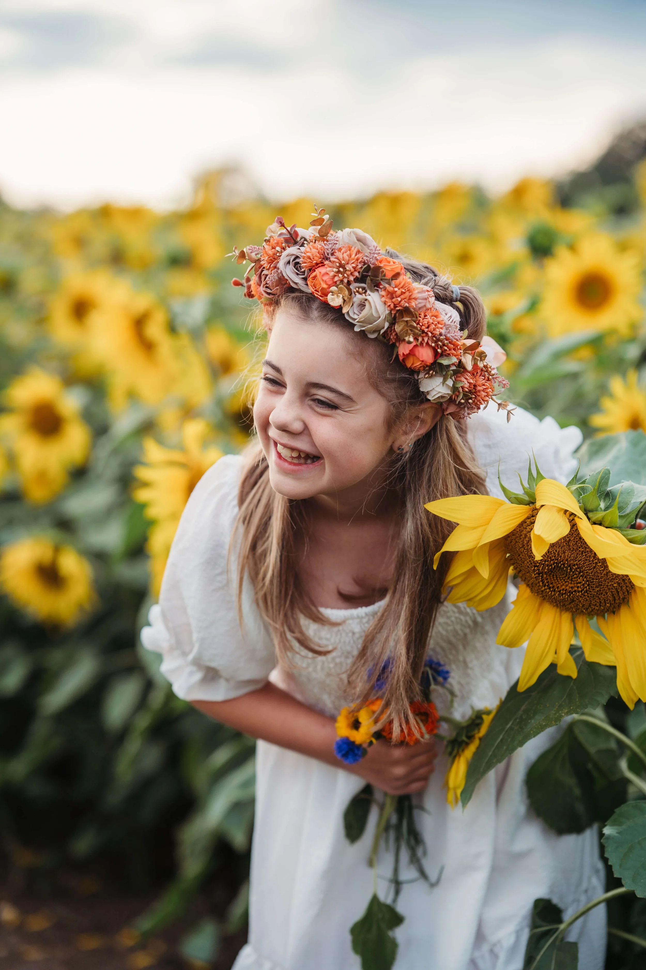 girl laughing in sunflower field portrait