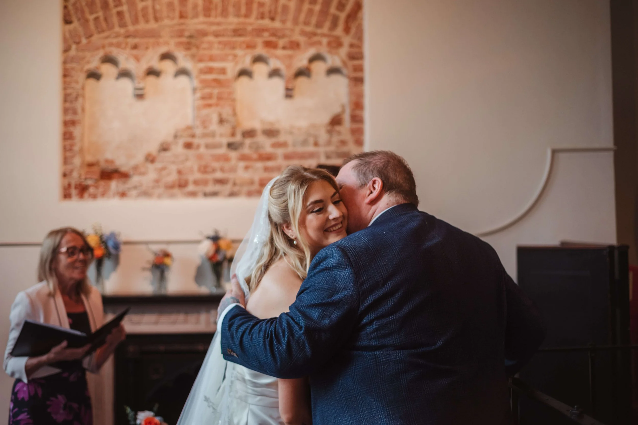 emotional photo of father kisses bride as he gives her away to the groom 