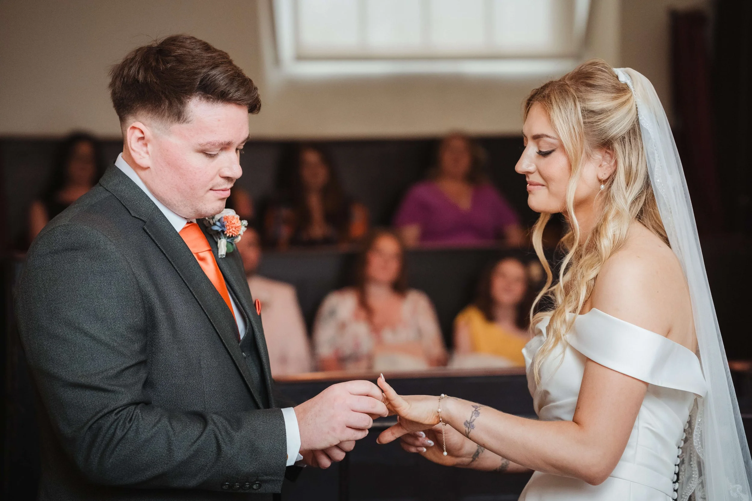 A bride and groom exchanging rings at their wedding ceremony.