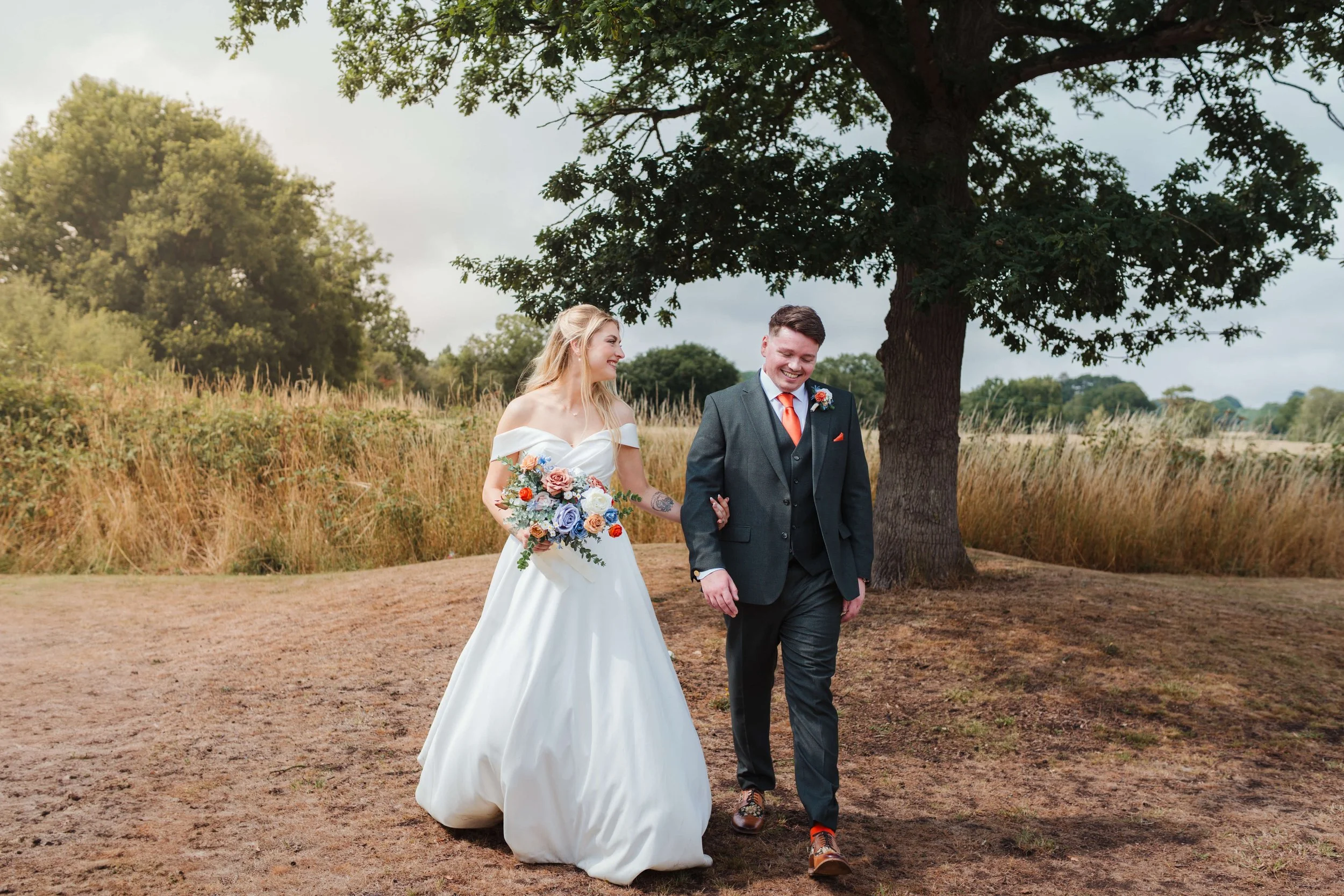 bride and groom walking hand in hand laughing 