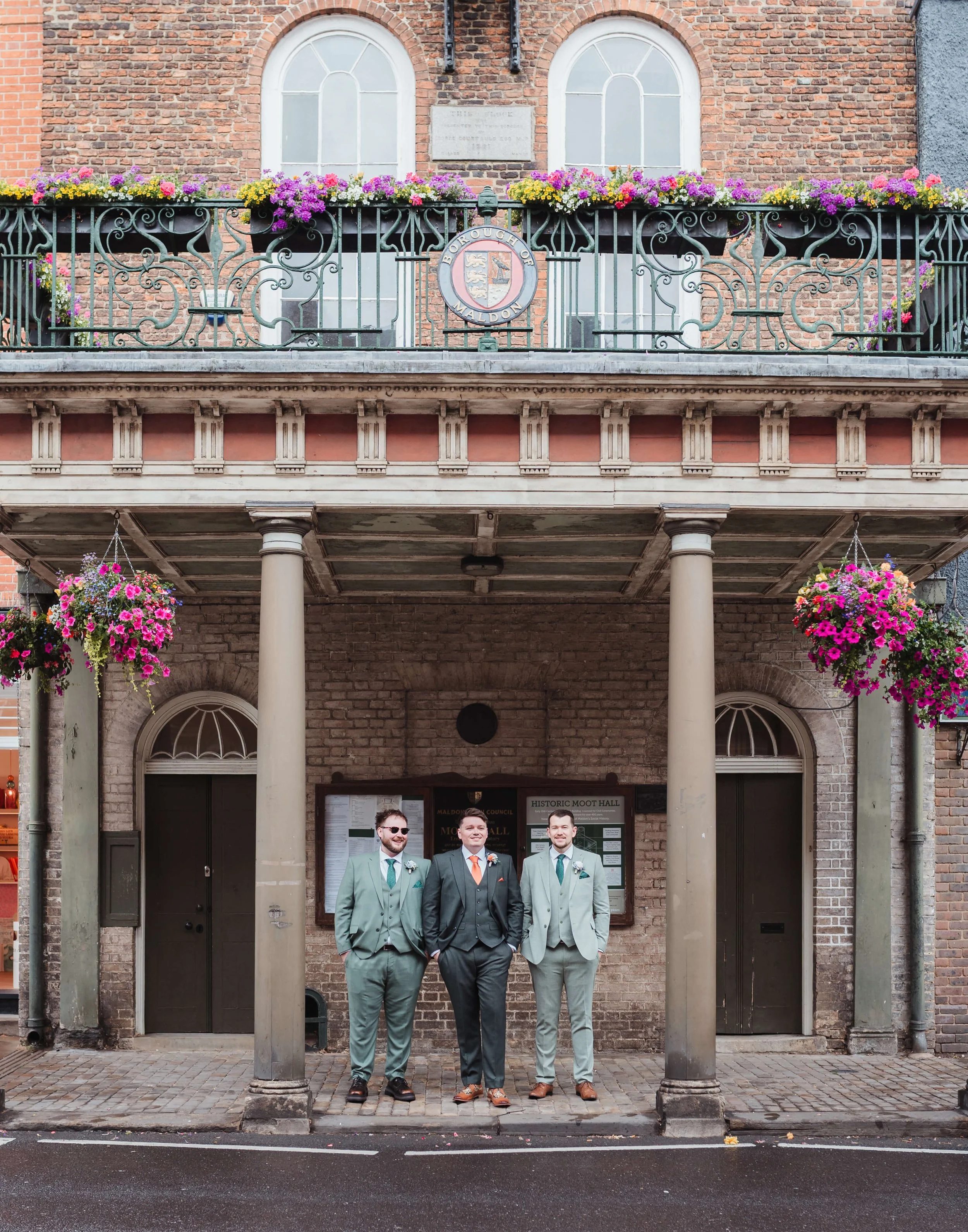 groom and groomsmen posing outside wedding venue