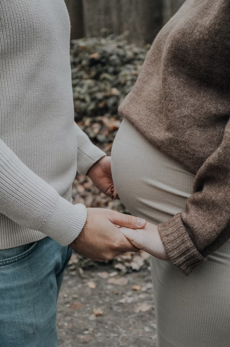 Pregnant person holding hands with partner