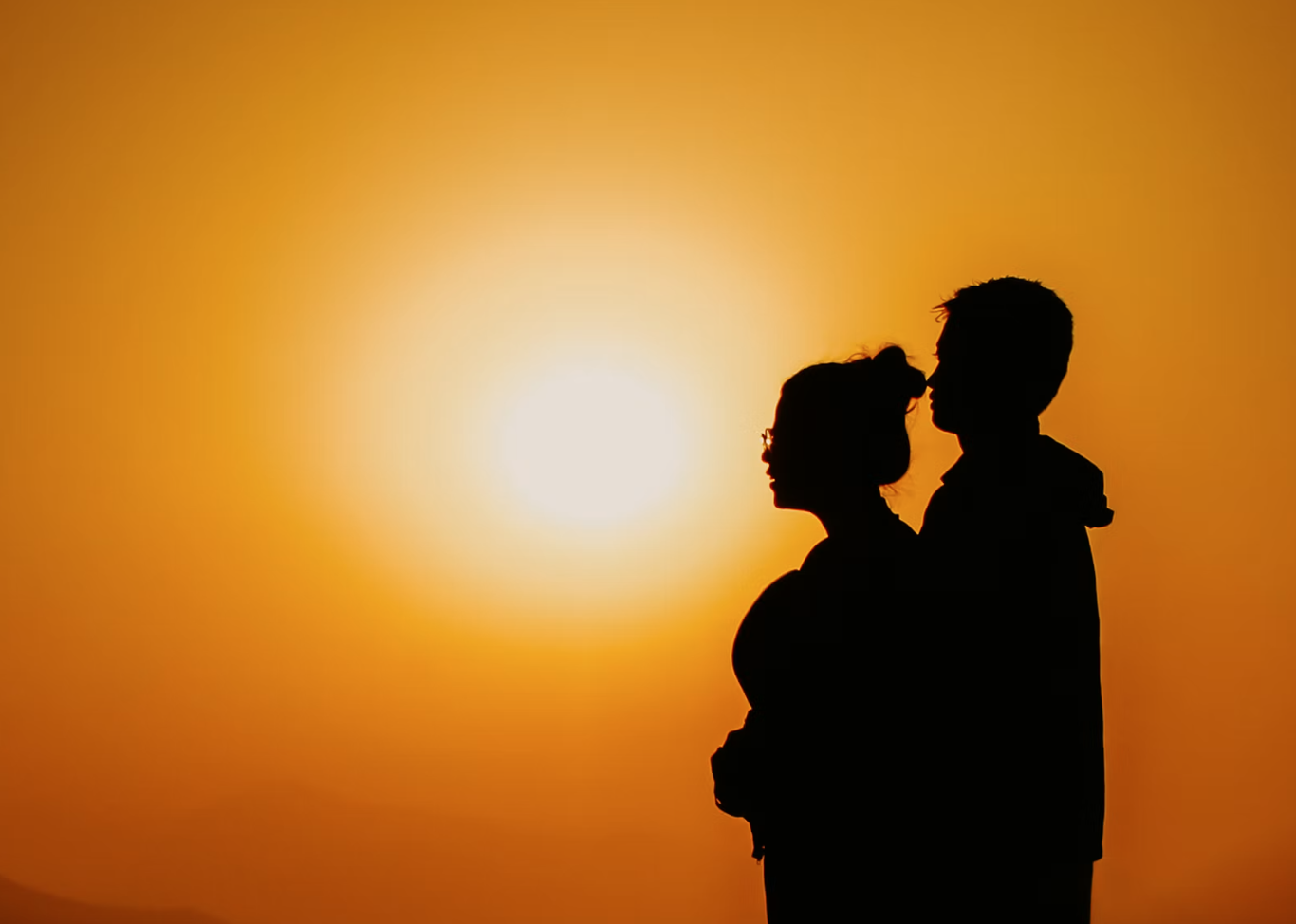 Expectant parents at sunset
