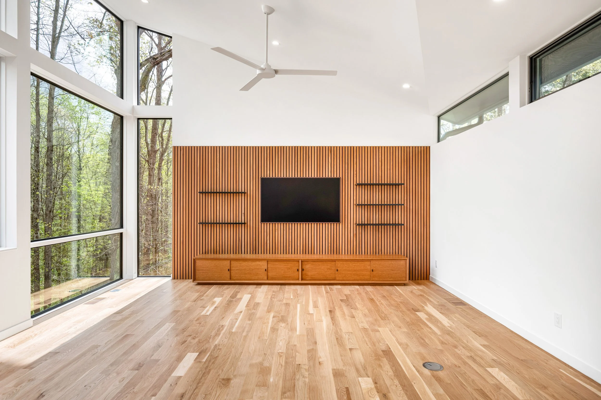 Dramatic forest view where the roof tilts up, and custom credenza and wood screened wall at the entertainment area. 