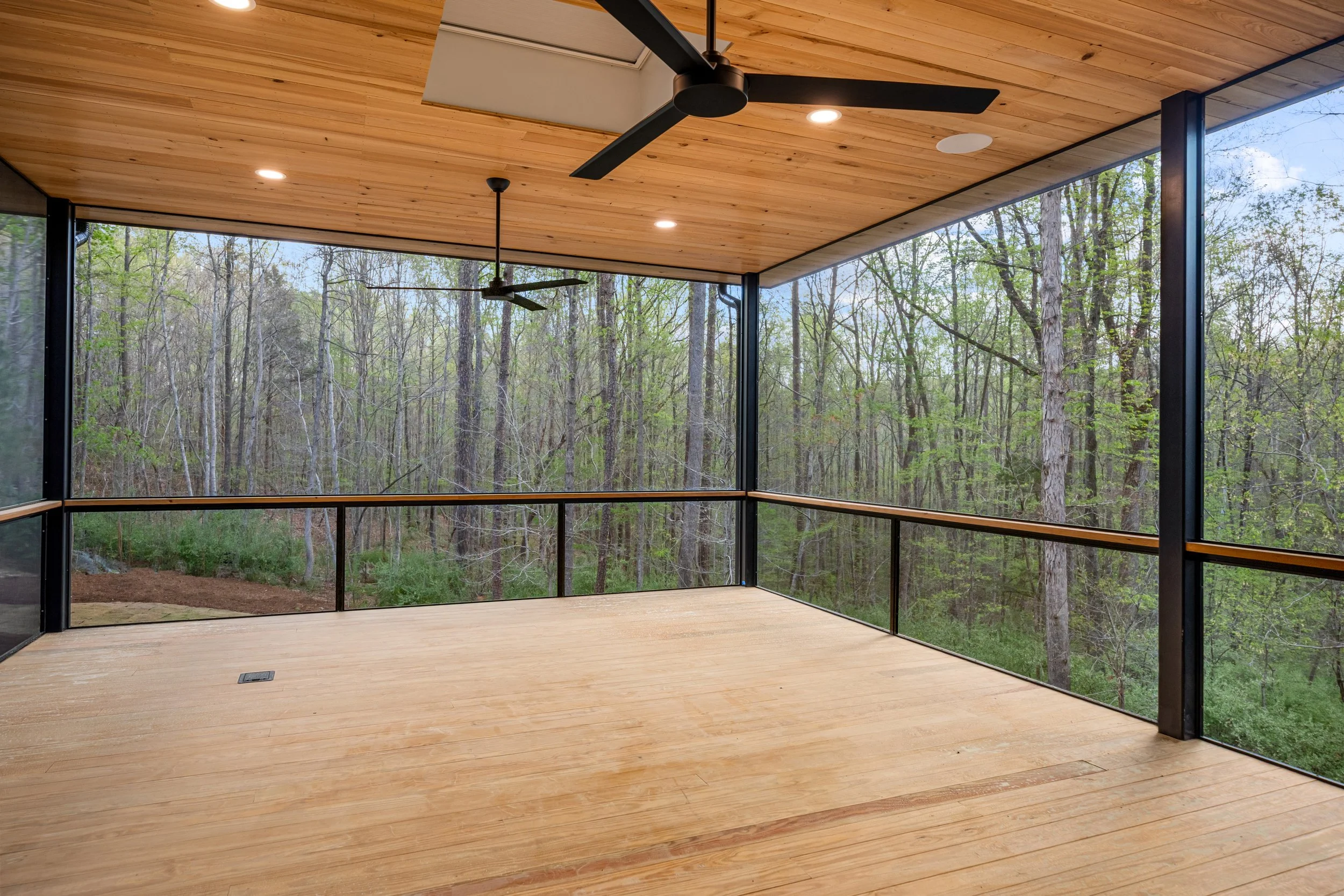  Screen porch view: custom steel railing with minimal detailng and large unbroken screen panels allow for a livable space with uninterrupted forest view. 