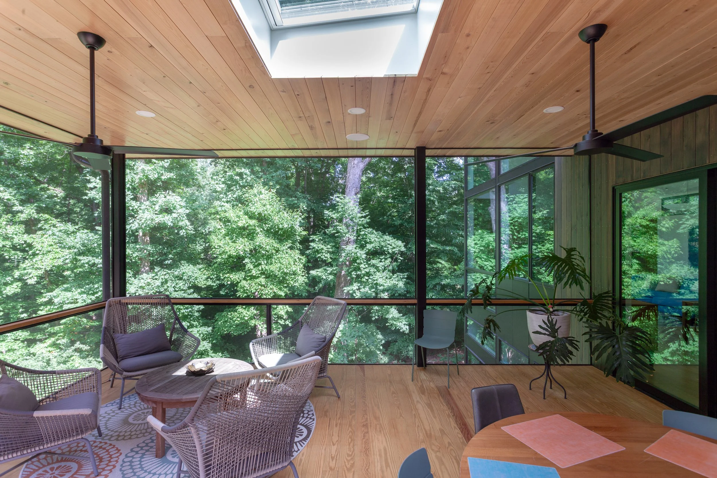  Screen porch view: custom steel railing with minimal detailng and large unbroken screen panels allow for a livable space with uninterrupted forest view. 