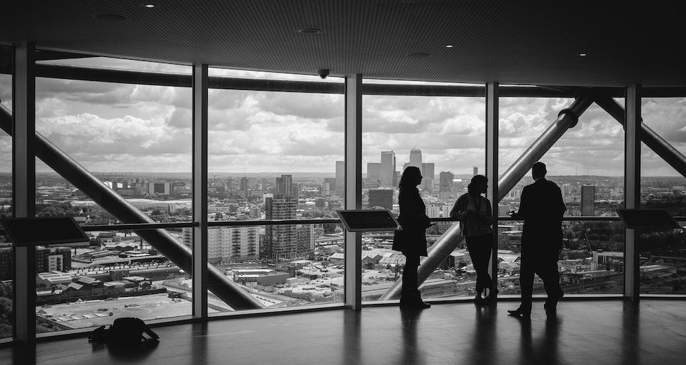 Young professionals talking in a business setting overlooking a cityscape.jpg