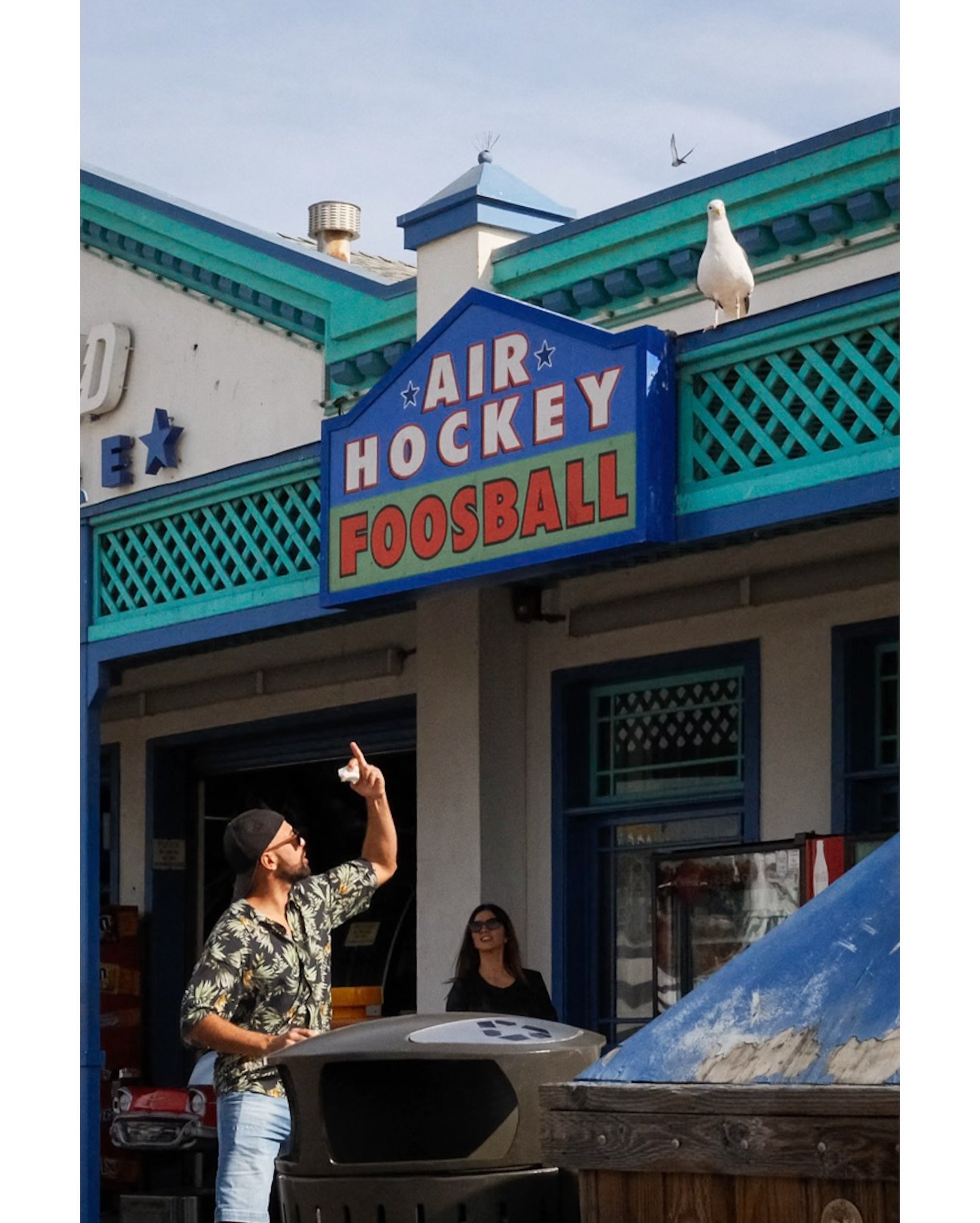 This guy was flipping the bird to the bird who just had made him one hot dog poorer. 

The gull was not quite full, and aimed for a second one. 
. 
Santa Monica Pier, California. 
November, 2024. 
. 
. 
. 
#streetphotography #timeless_streets #sweet_