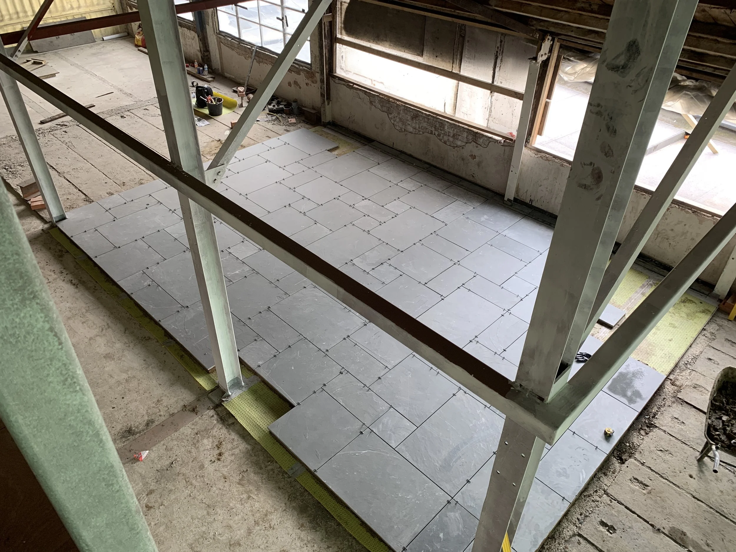 Green Brazil limestone being laid for indoor terrace