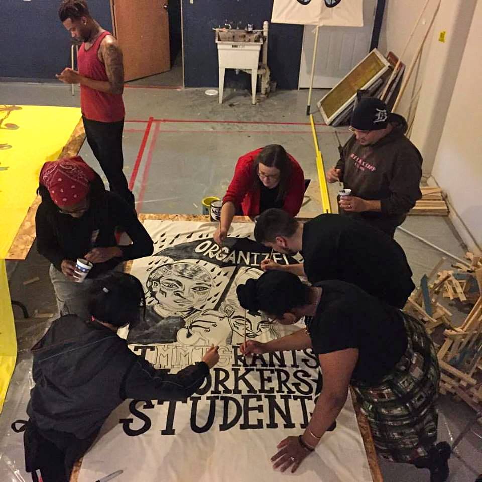  Volunteers paint a banner for immigrant rights.  