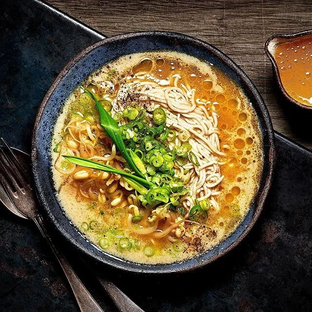 White miso soup with noodles, pickled bean sprouts, scallions, green chilli and ramsons wild garlic. Served with soured yellow tomato sauce and sichuan peppercorn oil
