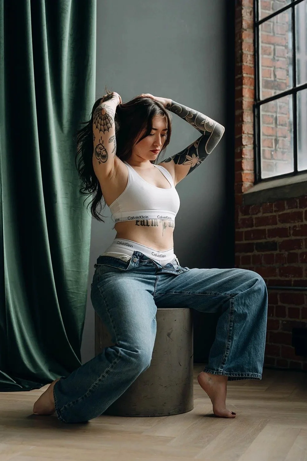 Woman playing with her hair on pedestal at a photo session in boudoir studio in Toronto