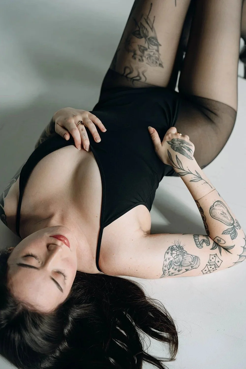 Woman lying on floor posing during boudoir photoshoot in boudoir studio in Toronto