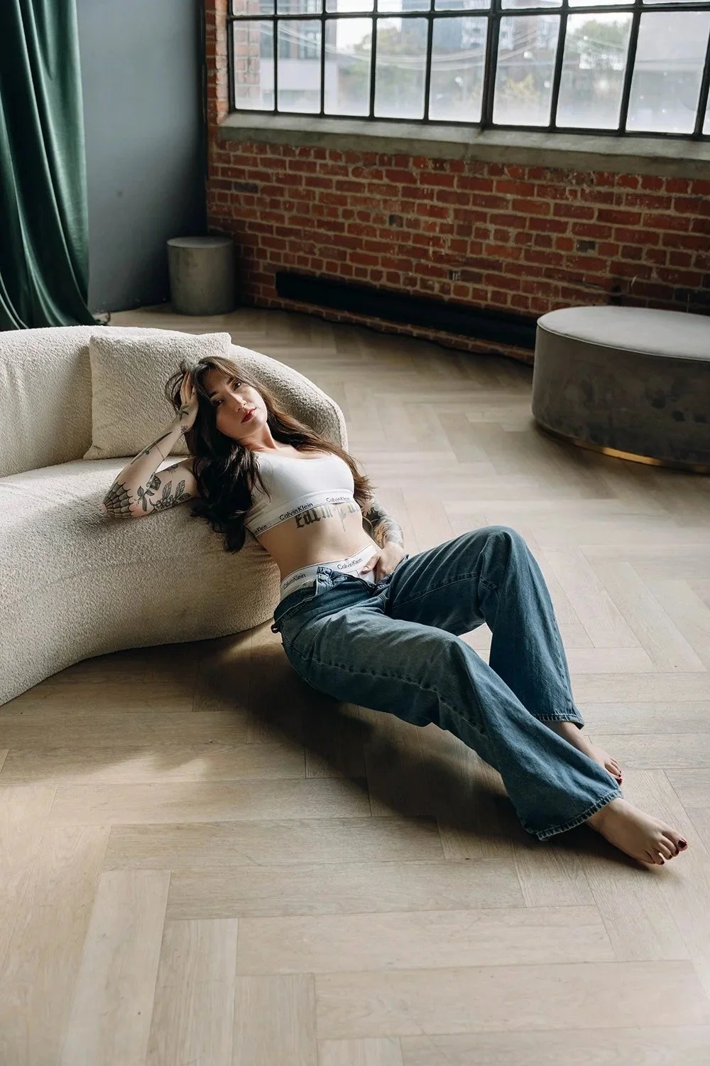 Woman sitting on floor leaning and posing in Toronto boudoir studio