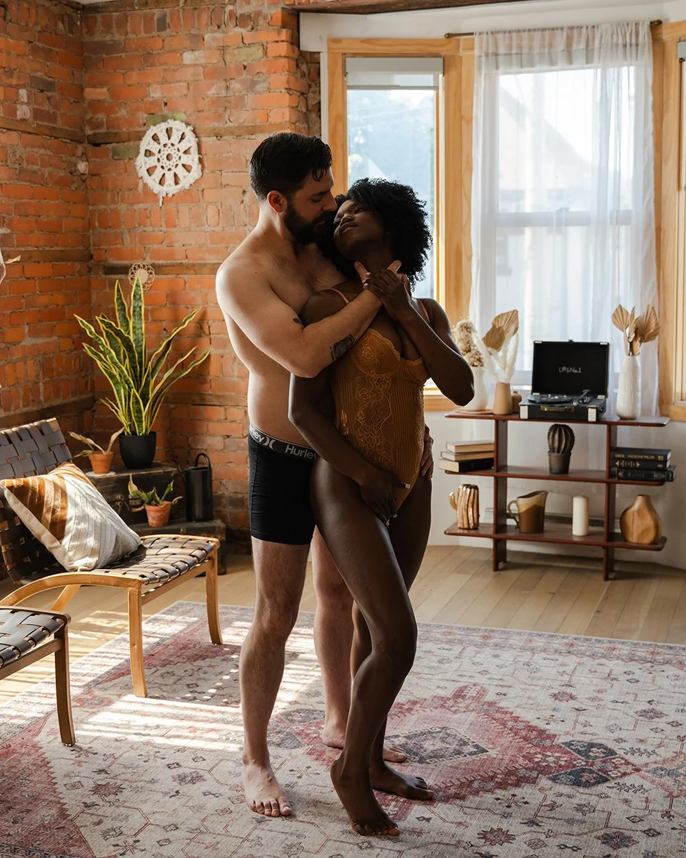 Artistic nude photography of a couple sharing a quiet, intimate moment during an erotic couples session.