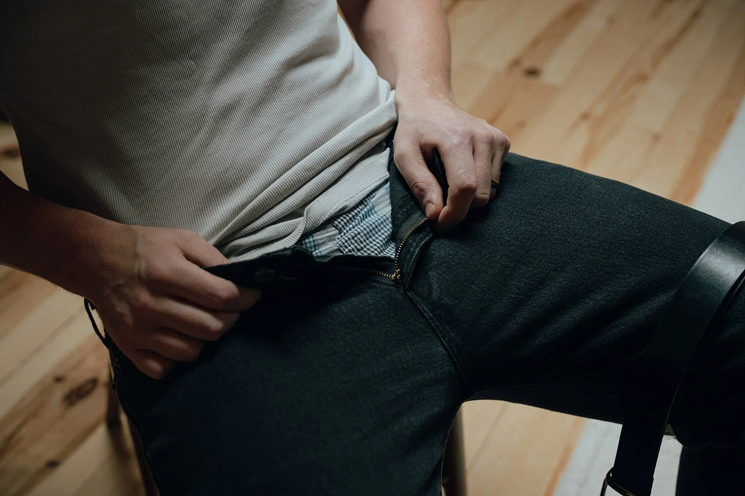 Man unzipping his jeans for an erotic photoshoot in Hamilton, Ontario