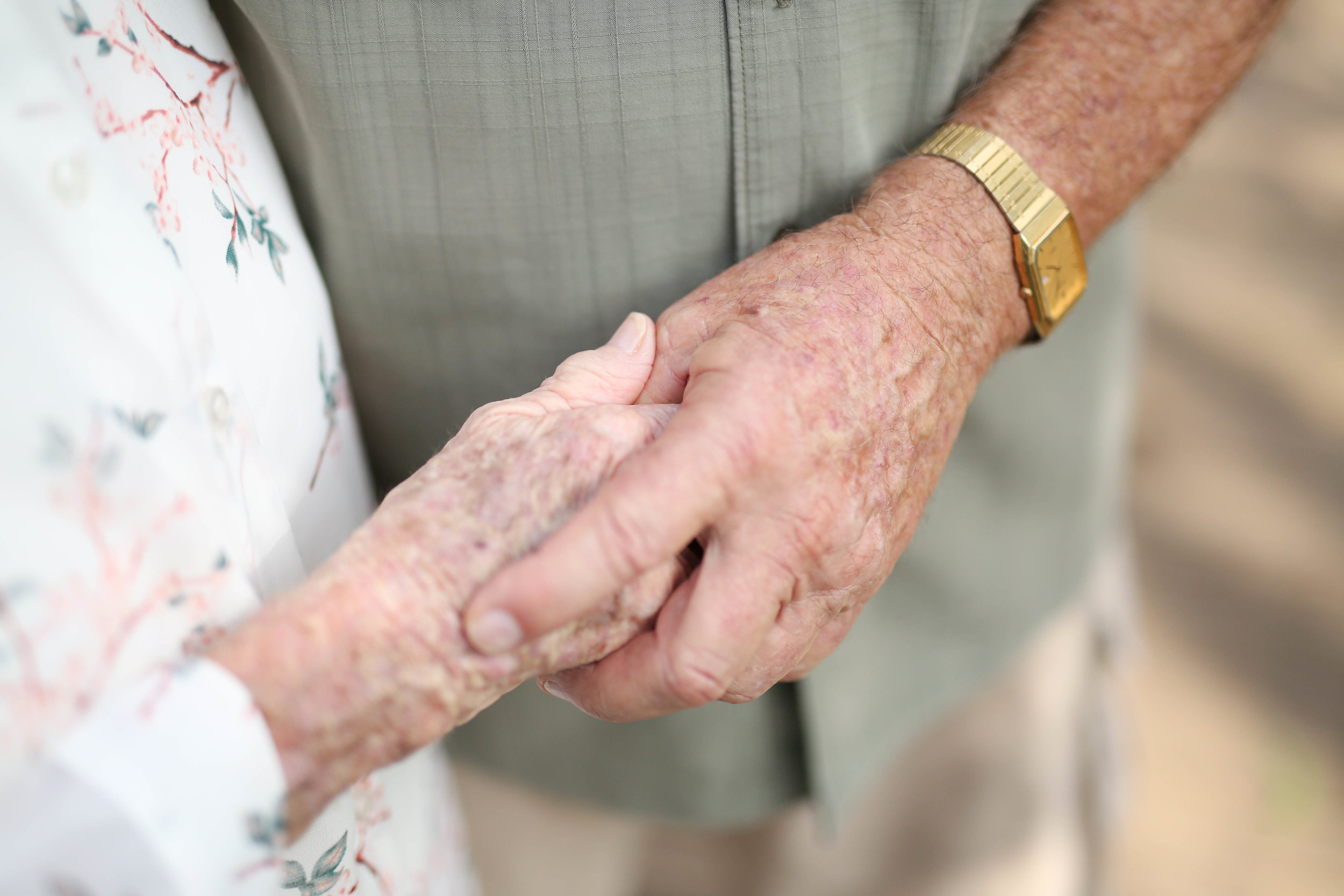 Elderly couple holding hands