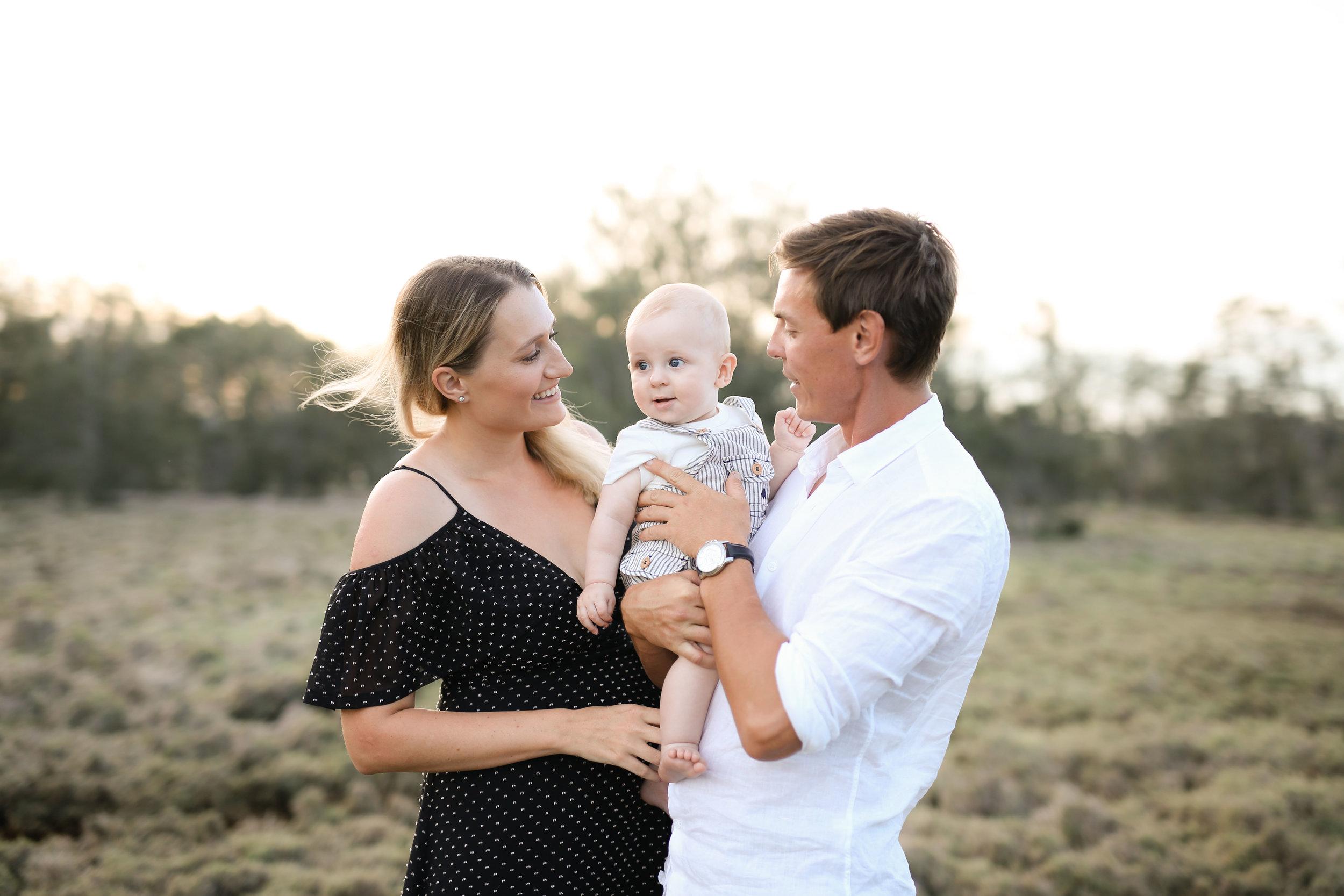 Little boy with his mum and dad in a grass field