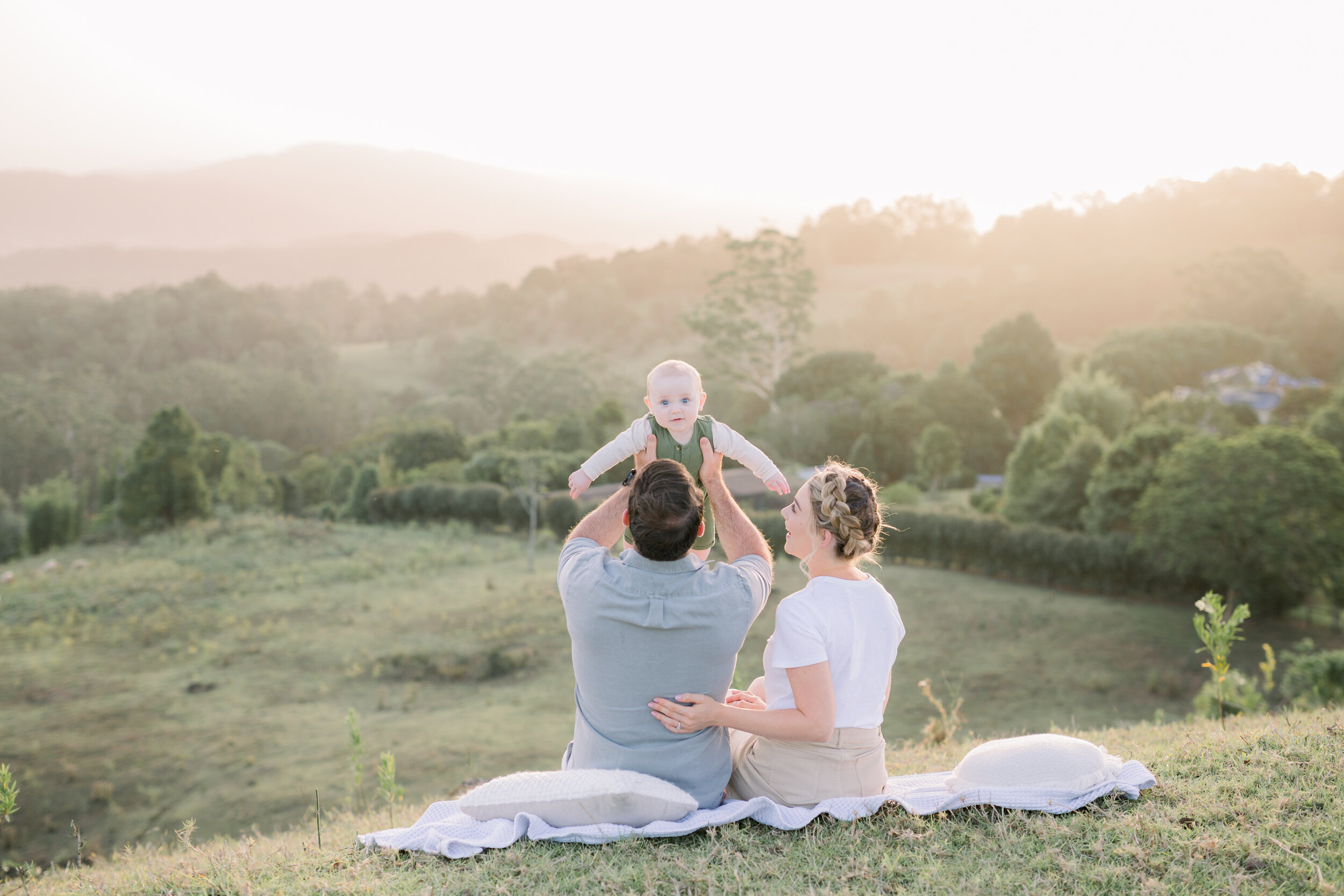 Family sitting on picnic rug in the mountains