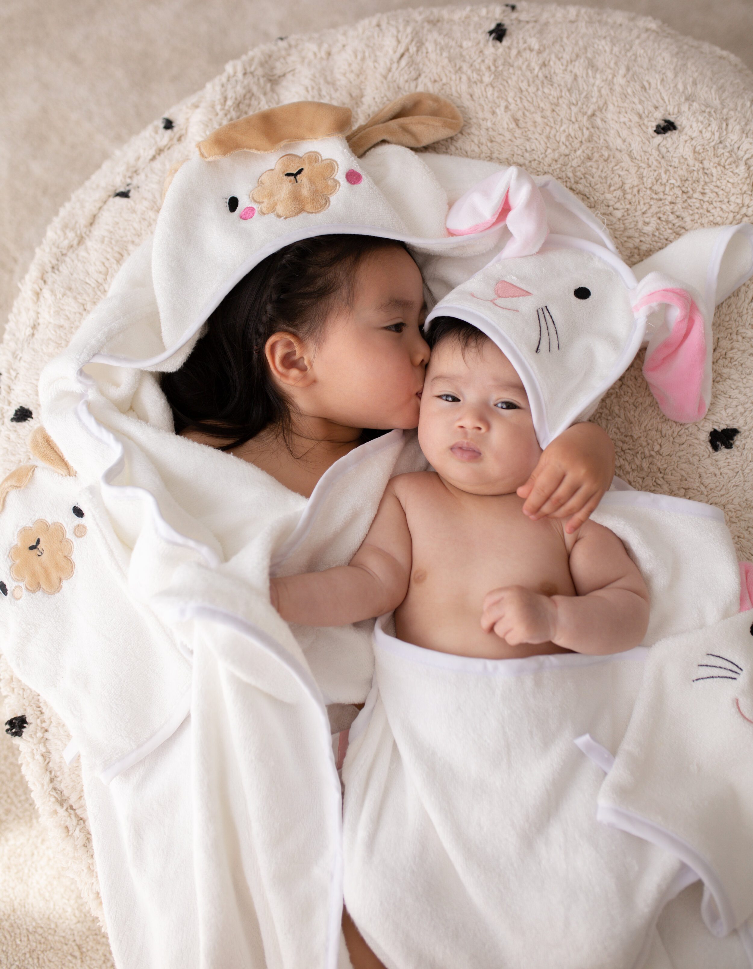 Two young children in hooded baby towels