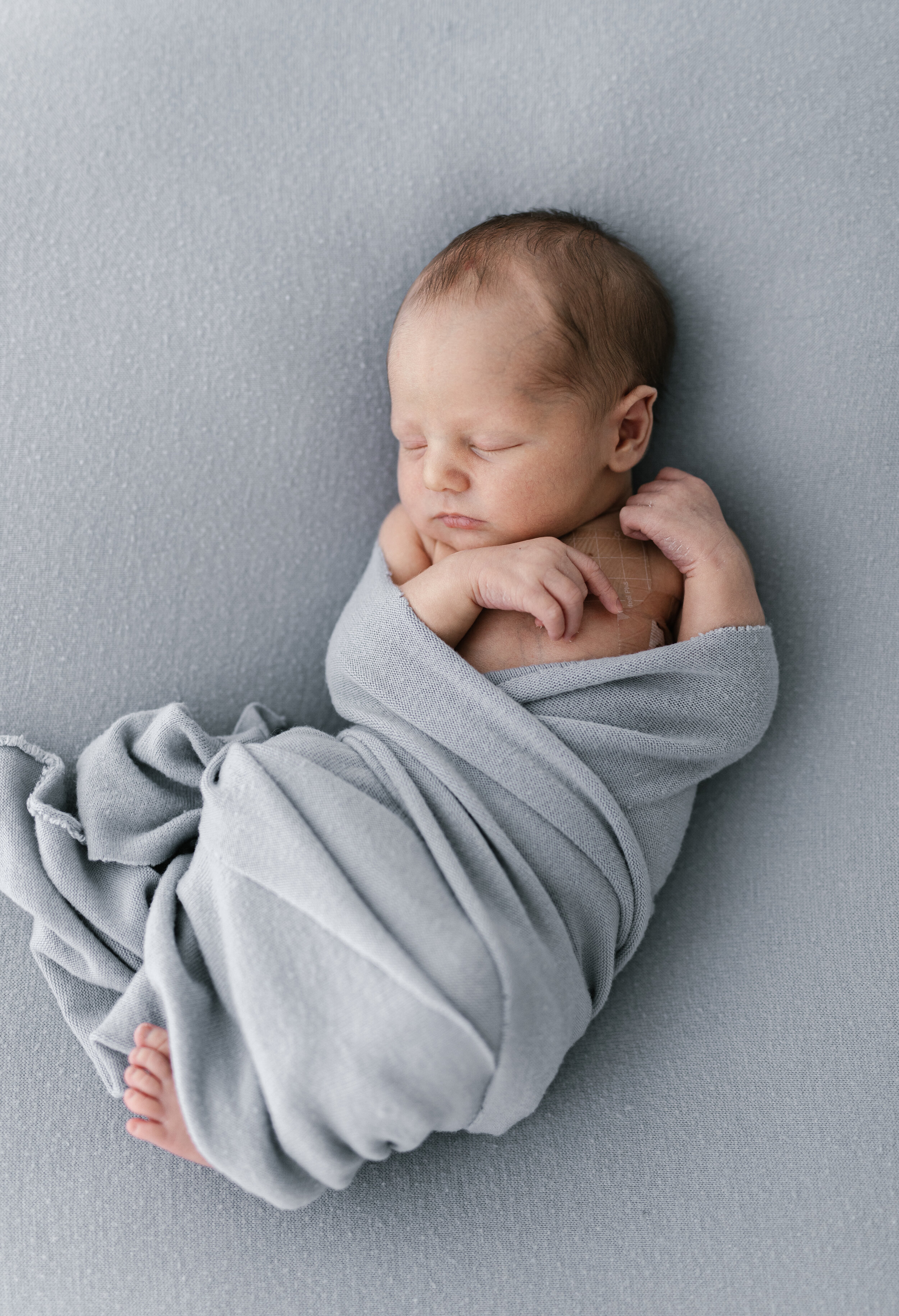 newborn baby boy wrapped in a soft blue blanket