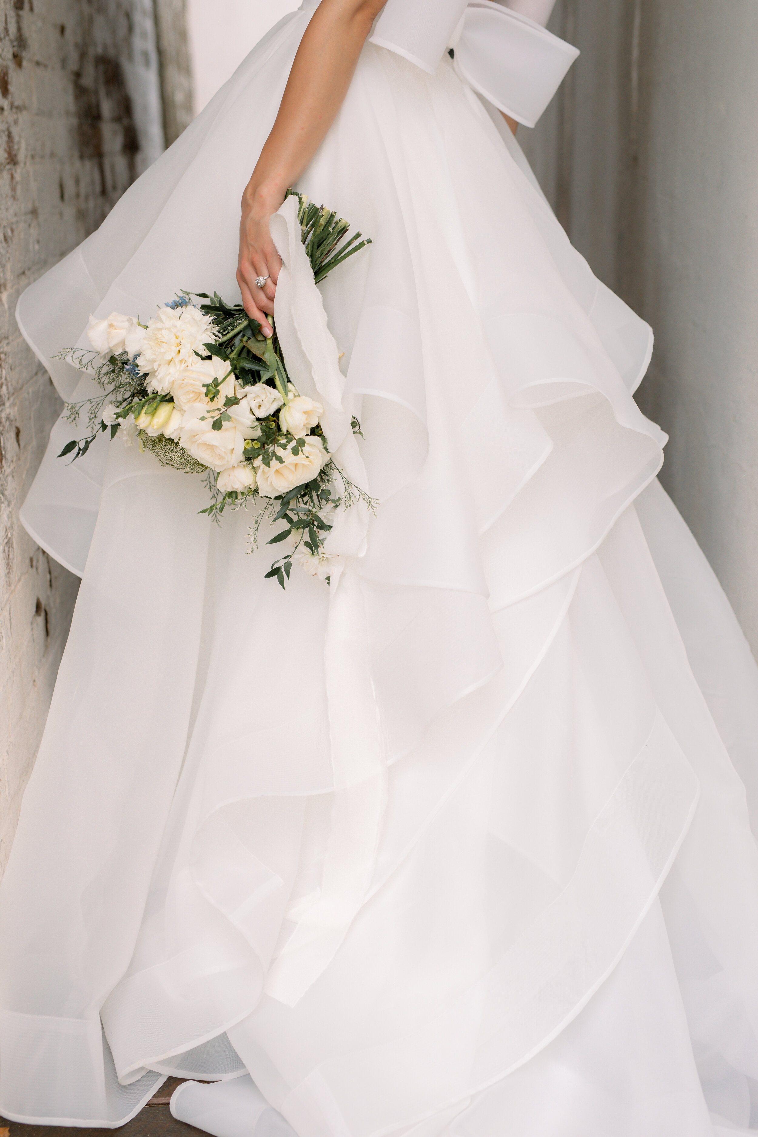 ruffled white wedding dress and floral bouquet 